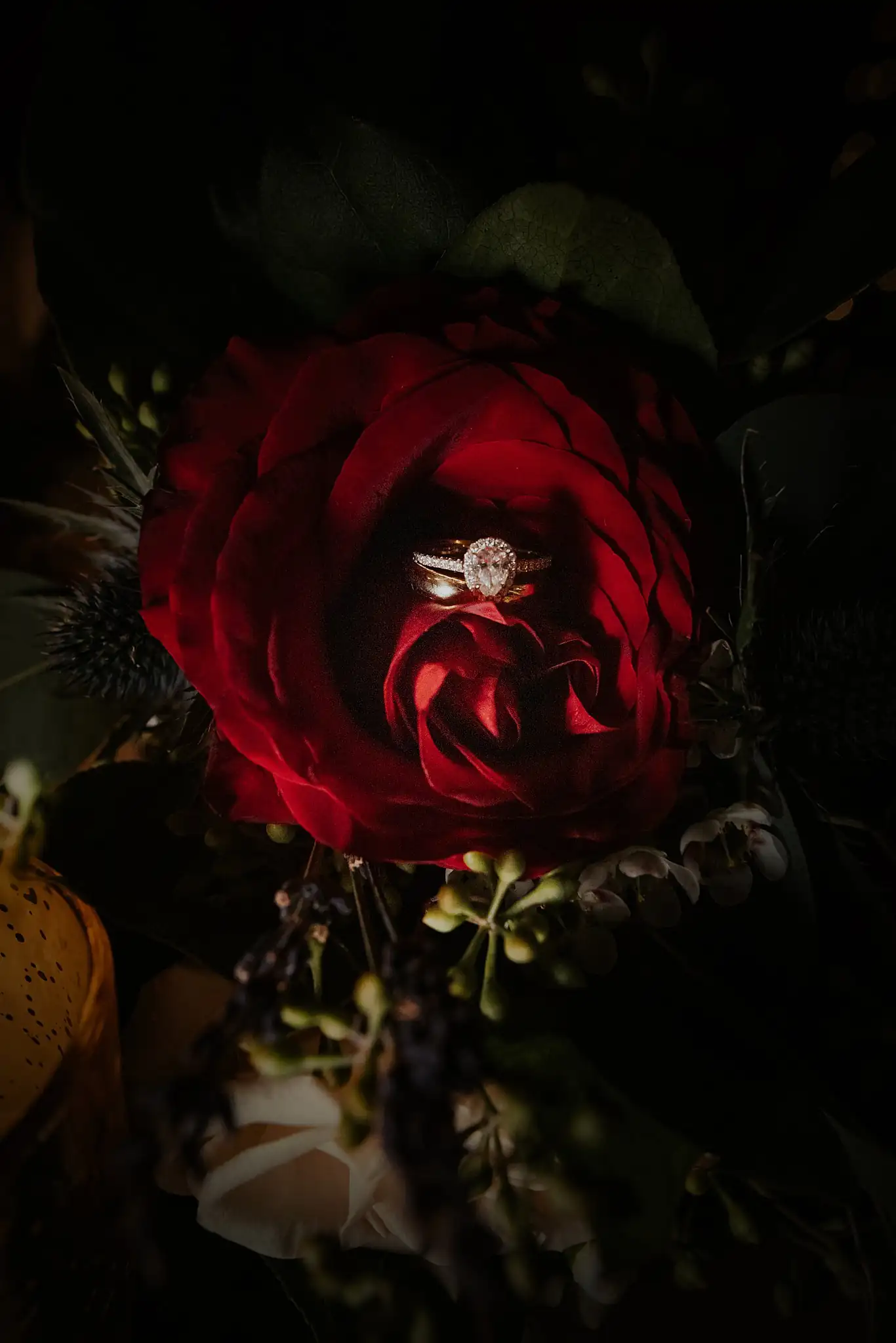 Wedding Florals: the bouquet of deep red garden roses against the dark, at a wedding at the Reid Barn in Cumming, GA