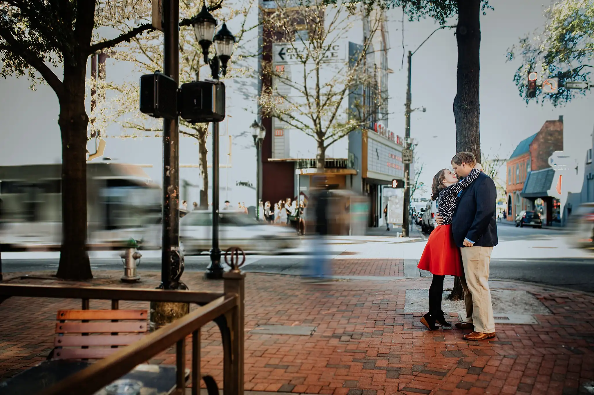 AtlantaWeddingPhotographers_0377.jpg Engagement Portraits: a kiss on the brick sidewalk as traffic passes, during their engagement session in downtown Athens, GA