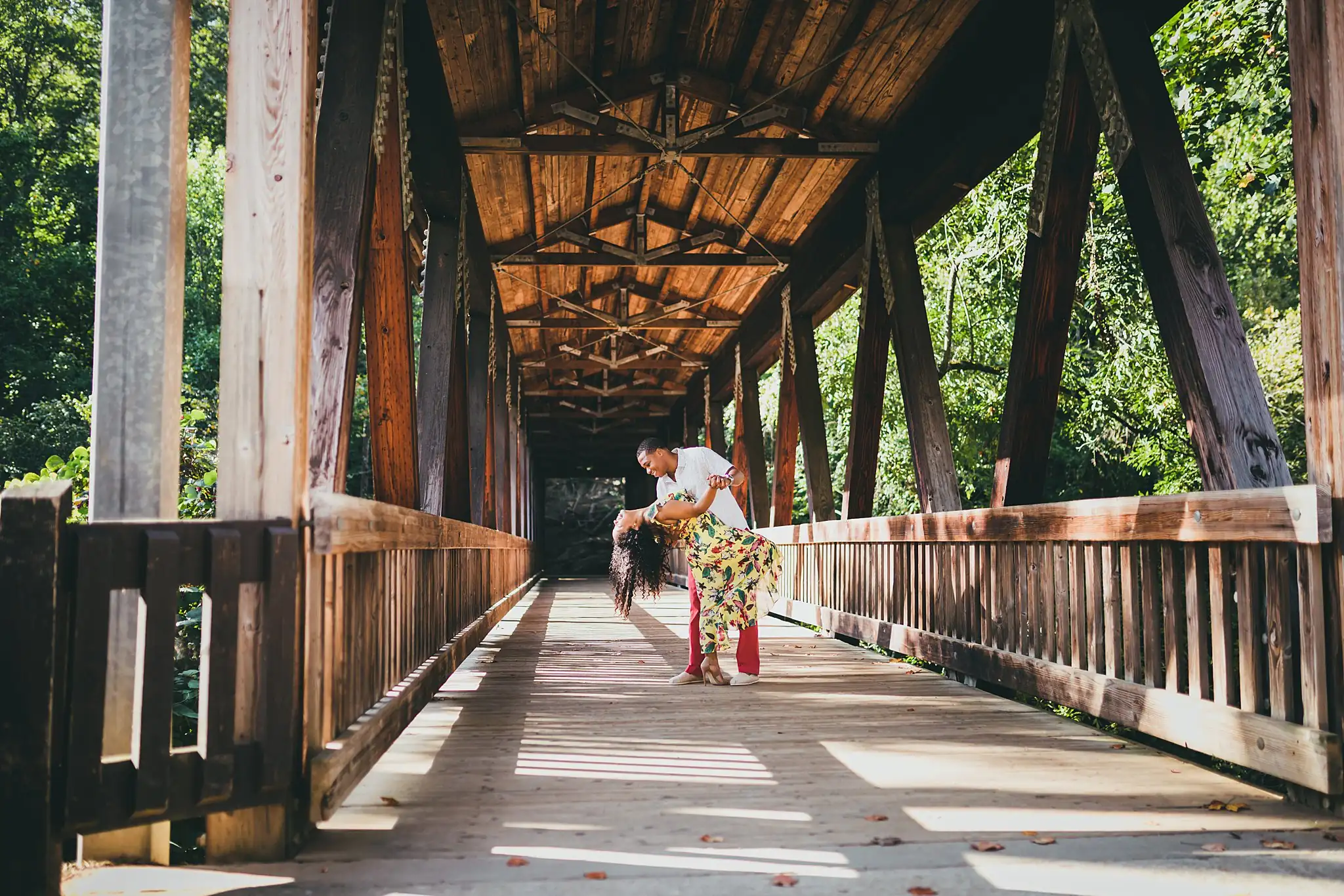 Vickery Falls at Roswell Mill Adventure Engagement Session Atlanta Wedding Photographers Engagement Portraits: a dip kiss in the middle of the covered bridge, during their engagement session at the Roswell Mill in Roswell, GA