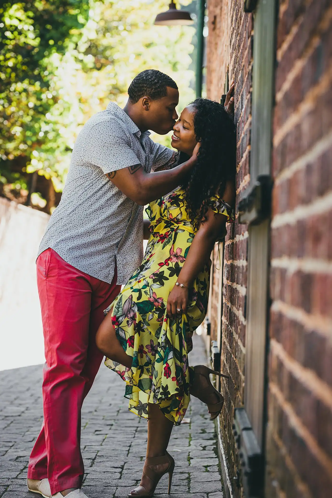 Vickery Falls at Roswell Mill Adventure Engagement Session Atlanta Wedding Photographers Engagement Portraits: him lifting her against the mill brickwork, during their engagement session at the Roswell Mill in Roswell, GA