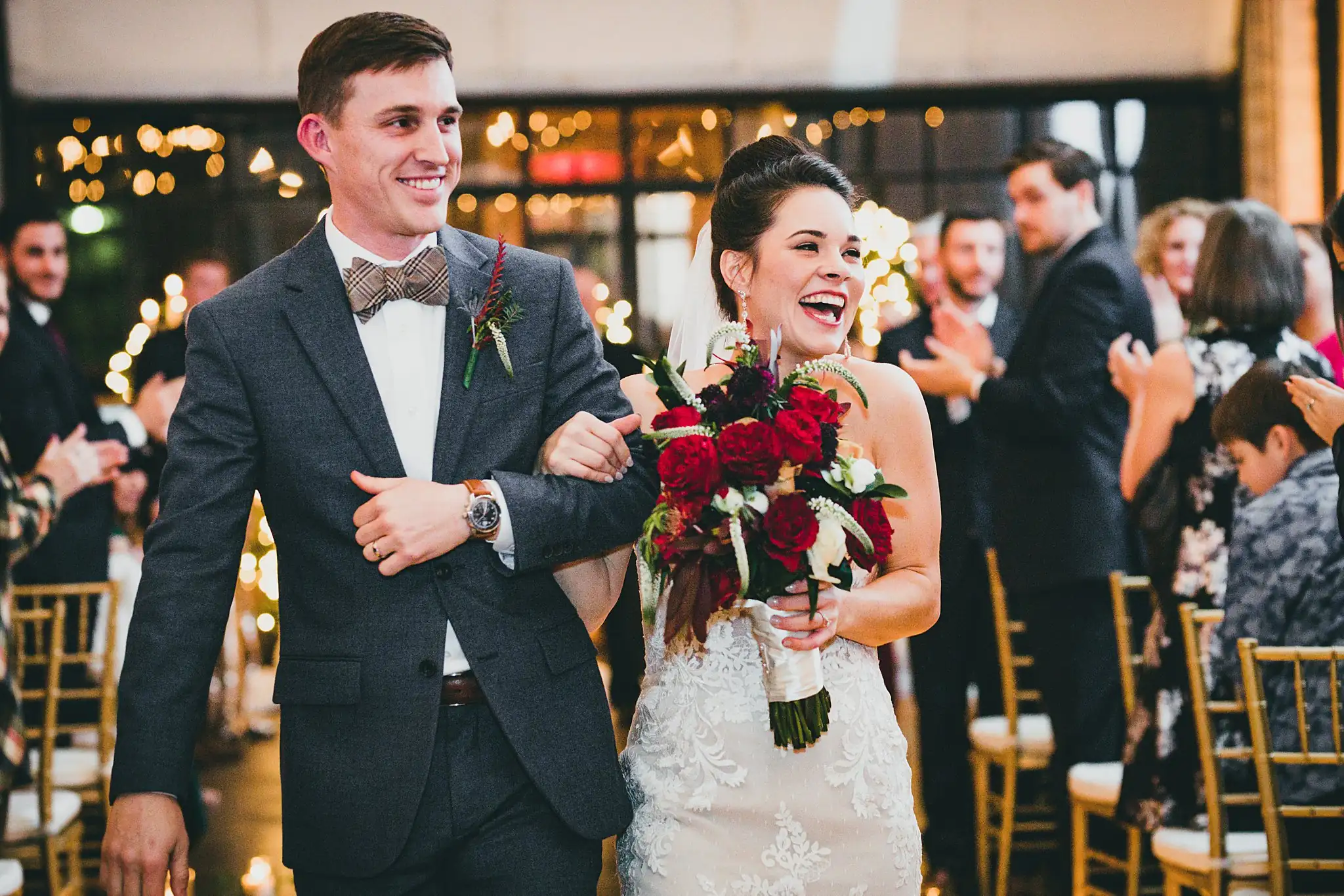 Recessional: the couple walking out as their guests applaud, at their wedding at the Westside Warehouse in Atlanta, GA