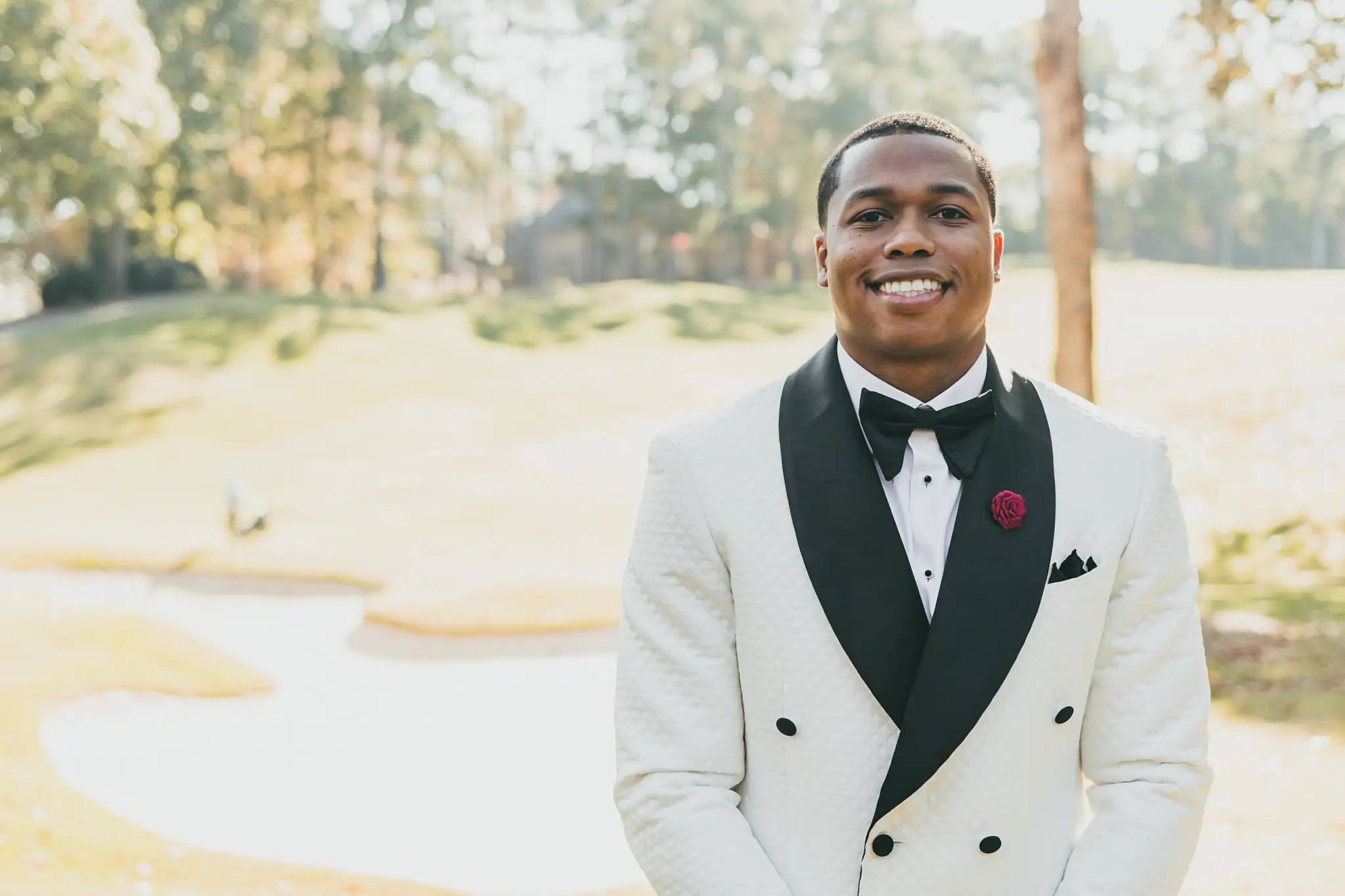 AtlantaWeddingPhotographers_0674.jpg Wedding Formals: the groom in his white dinner jacket out on the course, at their wedding at the Country Club of the South in Johns Creek, GA