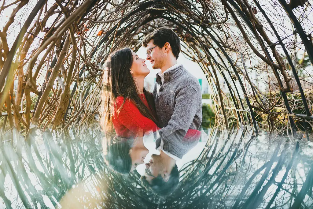 Engagement Portraits: a kiss inside the woven willow arch, during their engagement session at Barrington Hall in Roswell, GA