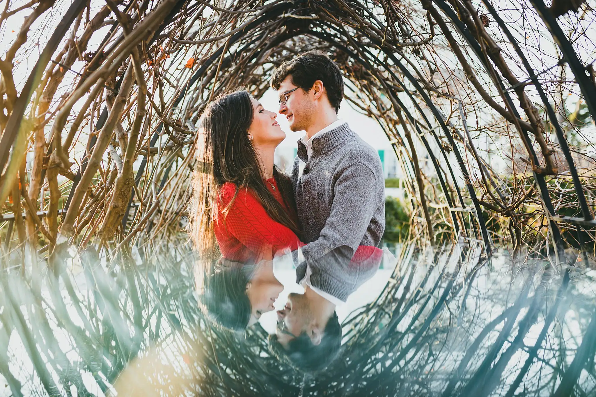Engagement Portraits: a kiss inside the woven willow arch, during their engagement session at Barrington Hall in Roswell, GA