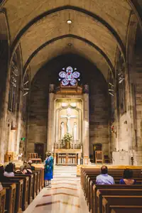 Wedding Ceremony: the long aisle of a vaulted stone church, at a wedding
