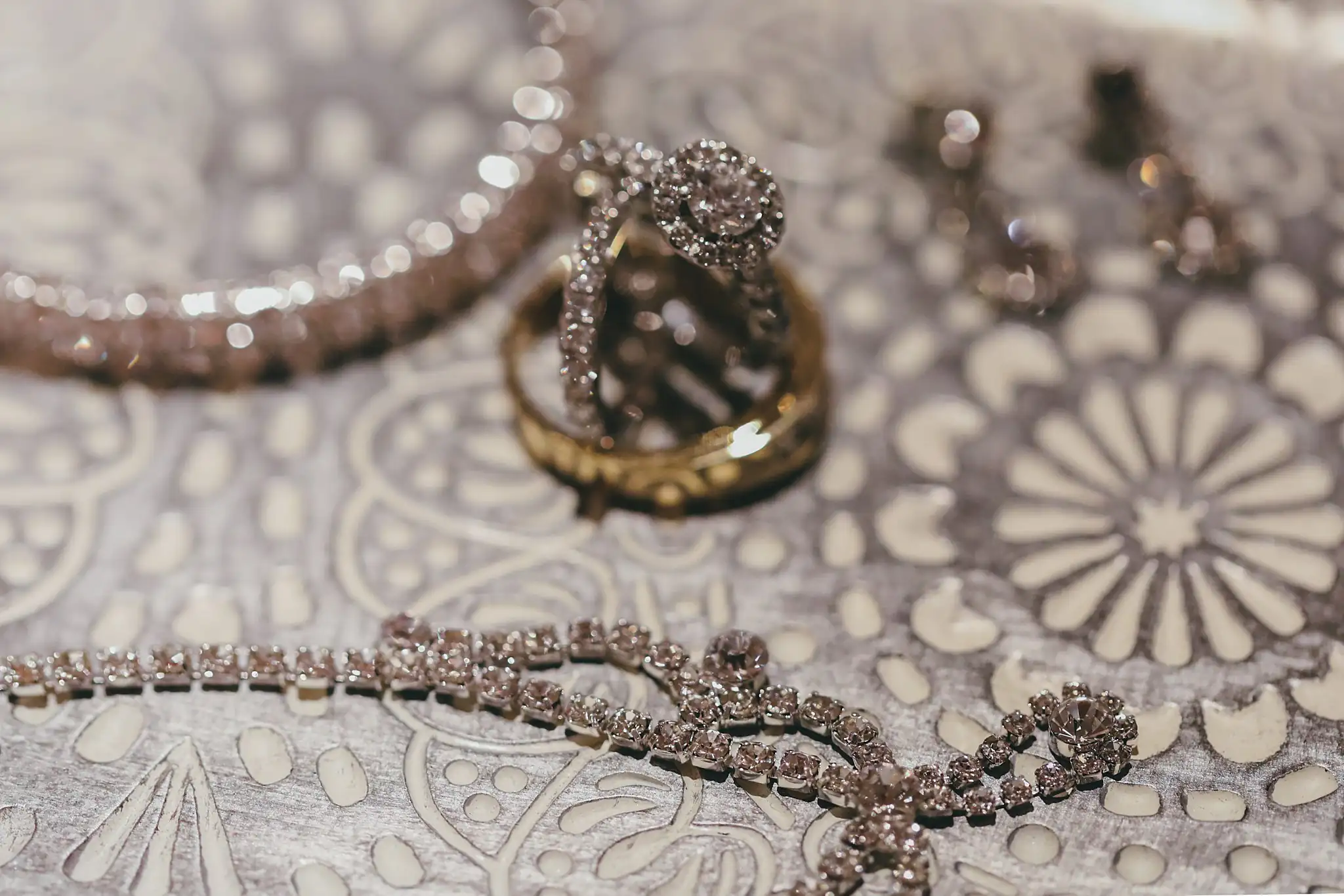 Wedding Details: a beaded bracelet, the rings and the earrings on beaded lace, at an elopement at Ventanas in Atlanta, GA