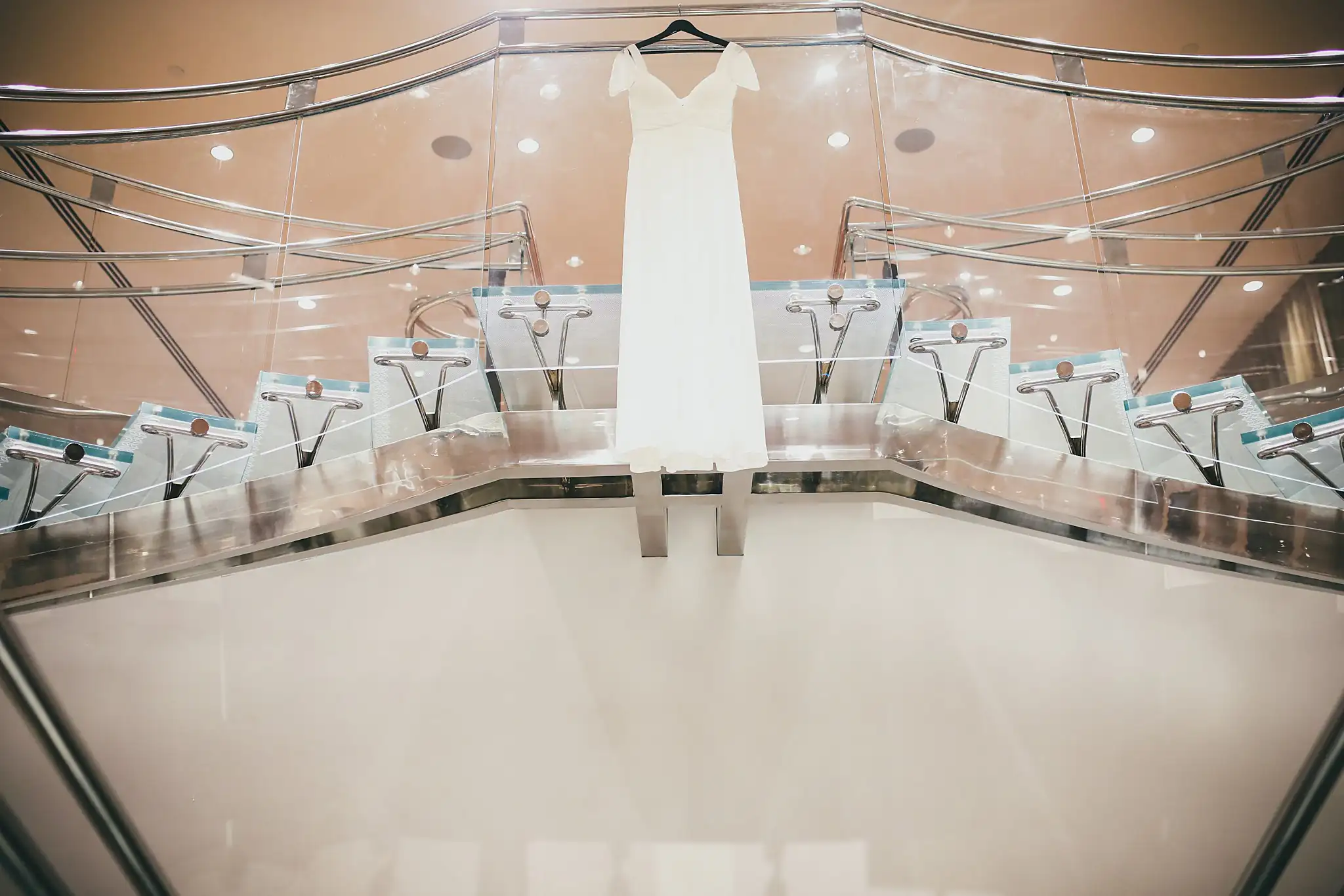 Wedding Details: the wedding gown hanging over the curved glass balcony rail, at an elopement at Ventanas in Atlanta, GA