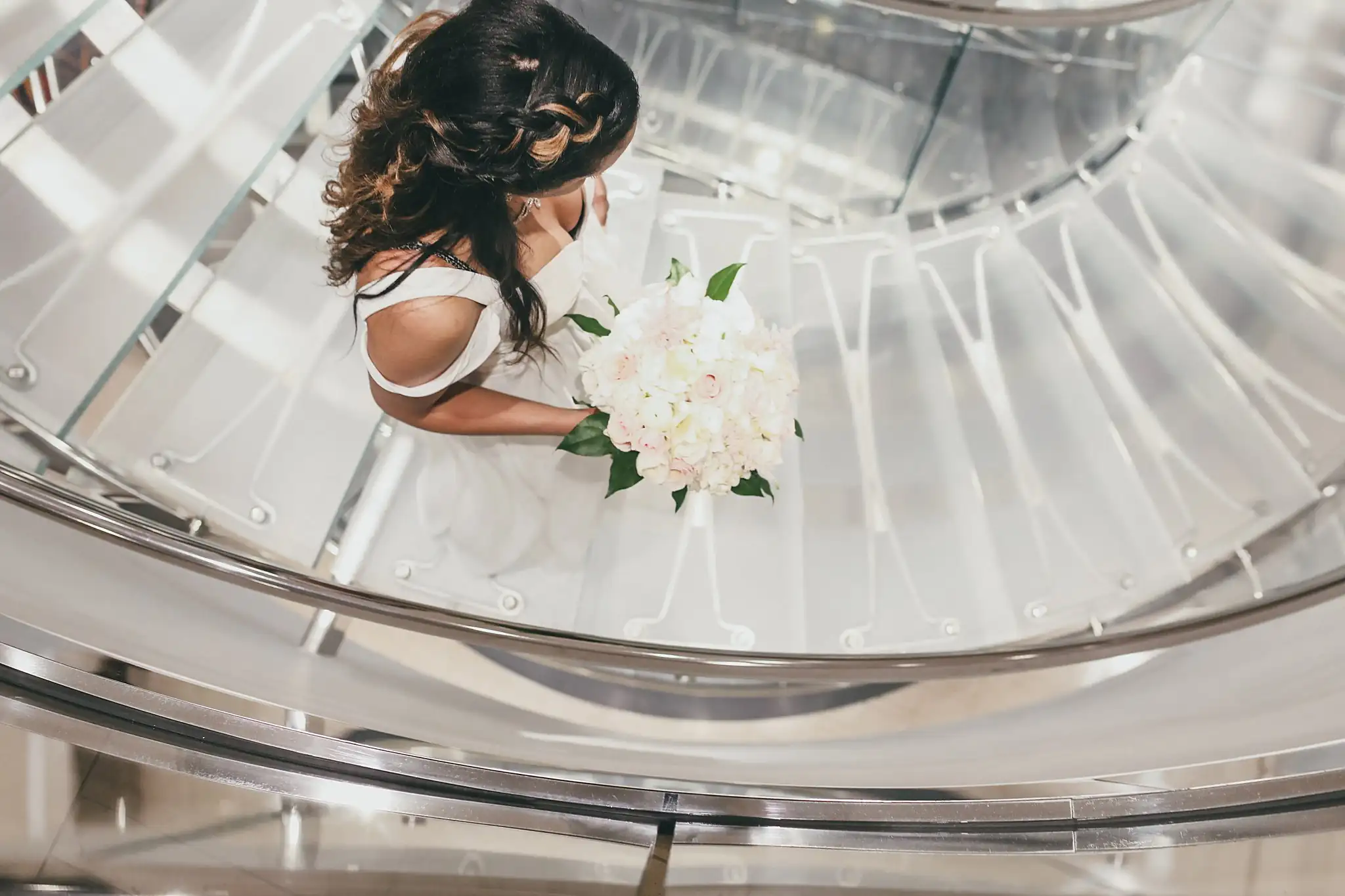 Getting Ready: the bride on the glass staircase seen from above, before their elopement at Ventanas in Atlanta, GA