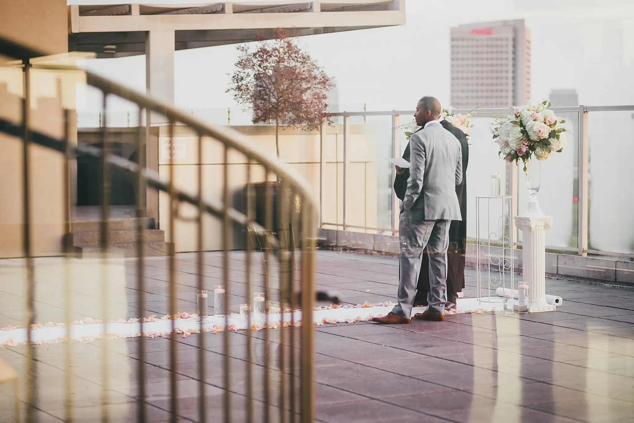 Wedding Ceremony: the officiant waiting at the end of the rooftop aisle, at their elopement at Ventanas in Atlanta, GA