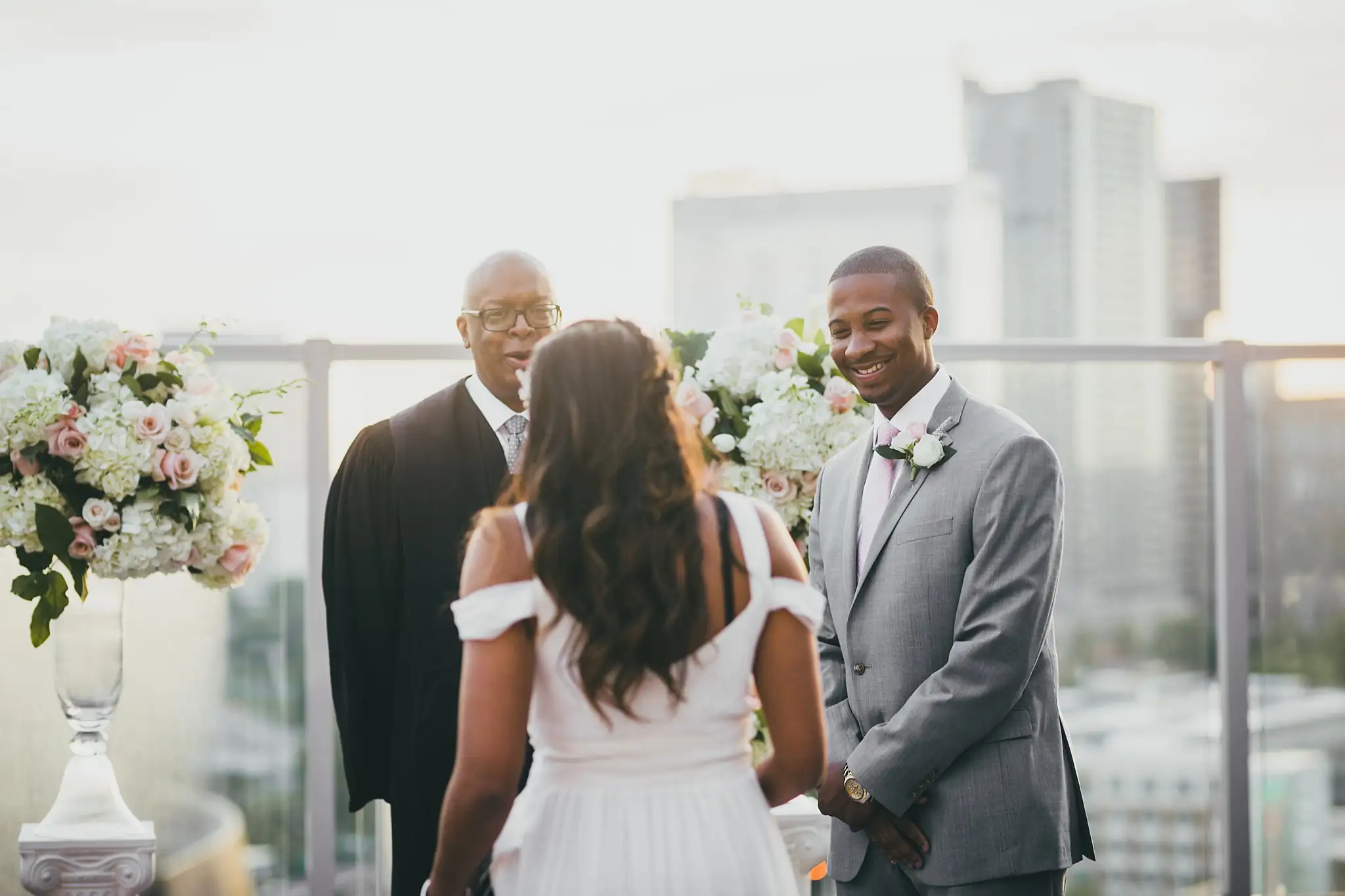 Wedding Ceremony: the couple standing before the officiant as the groom smiles, at their elopement at Ventanas in Atlanta, GA