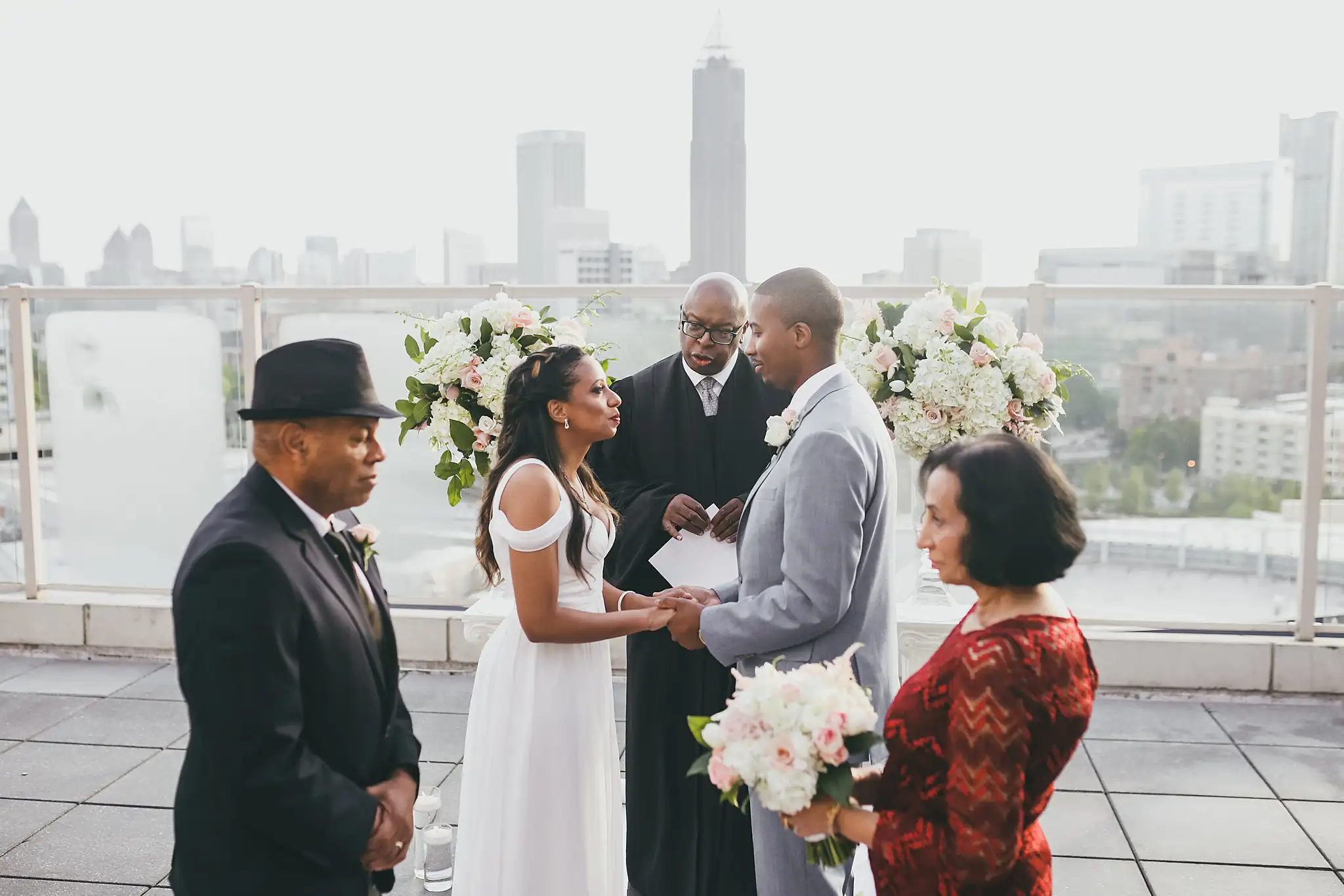 Wedding Ceremony: the couple exchanging vows with their family beside them, at their elopement at Ventanas in Atlanta, GA