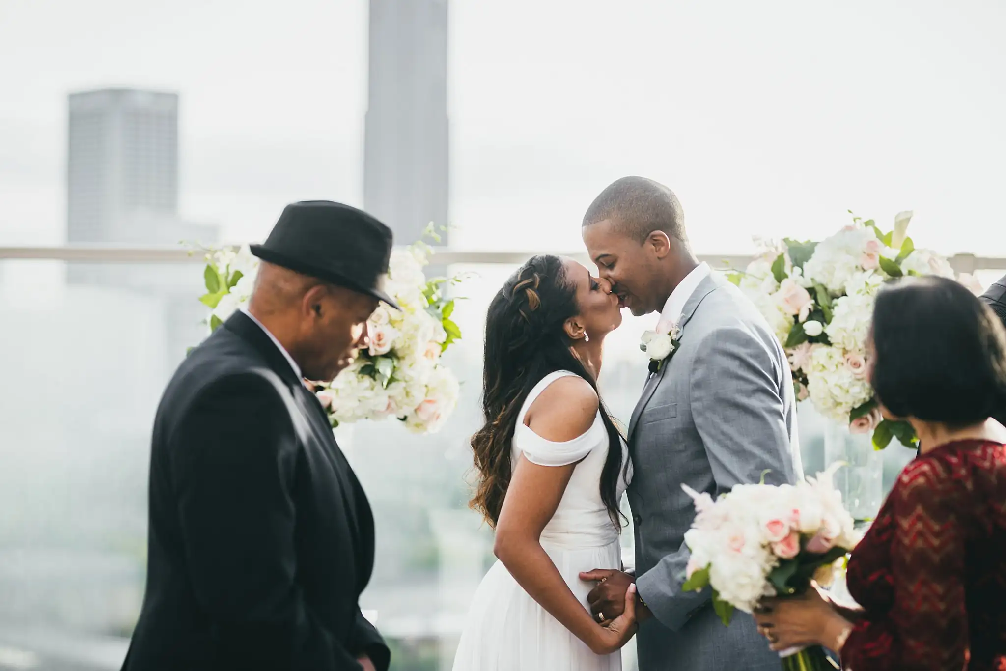 Wedding Ceremony: the first kiss with their family standing beside them, at their elopement at Ventanas in Atlanta, GA