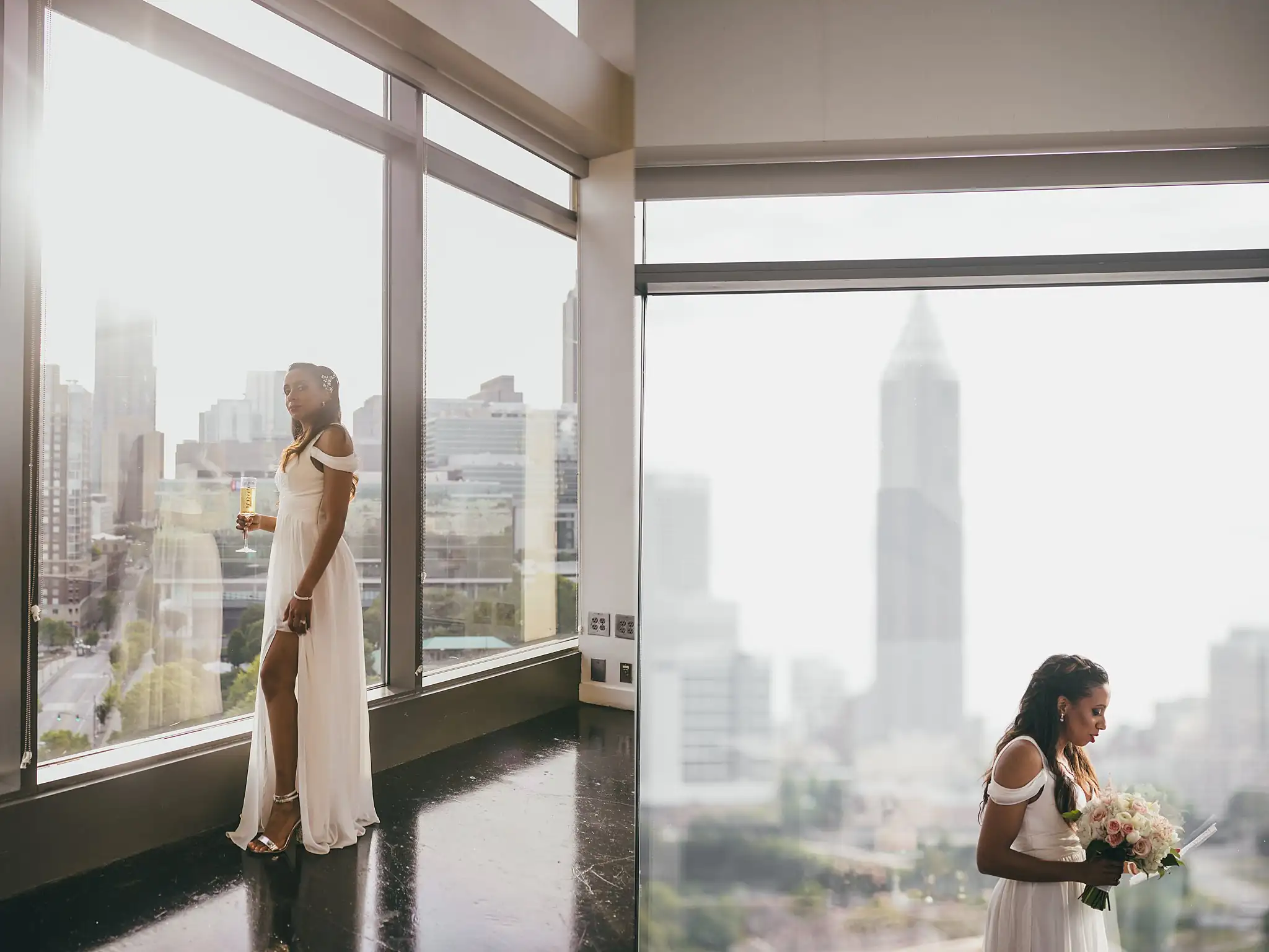 Bridal Portraits: the bride at the floor-to-ceiling windows above downtown, at their elopement at Ventanas in Atlanta, GA