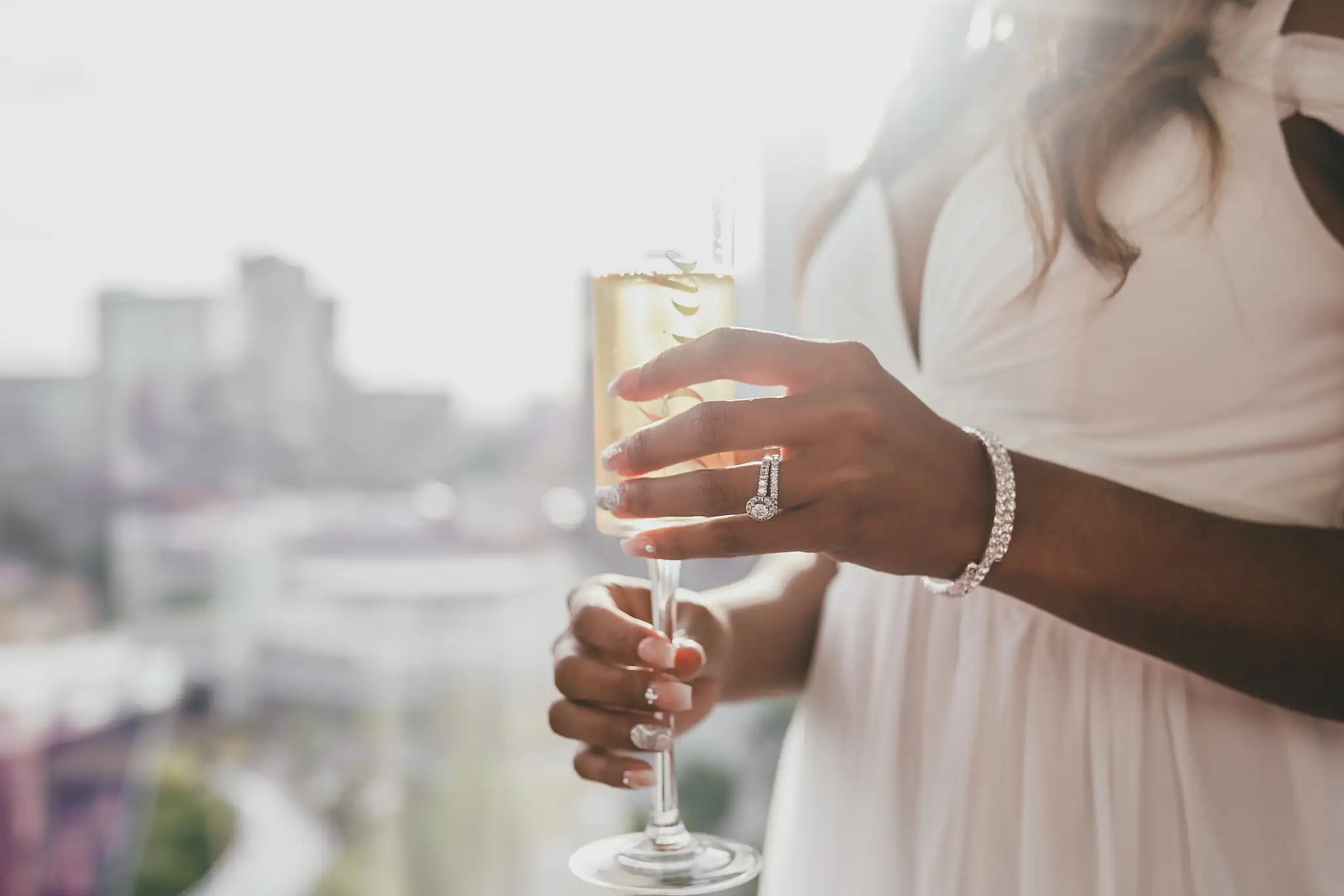 Wedding Details: the bride's hand and her wedding band around a champagne flute, at an elopement at Ventanas in Atlanta, GA