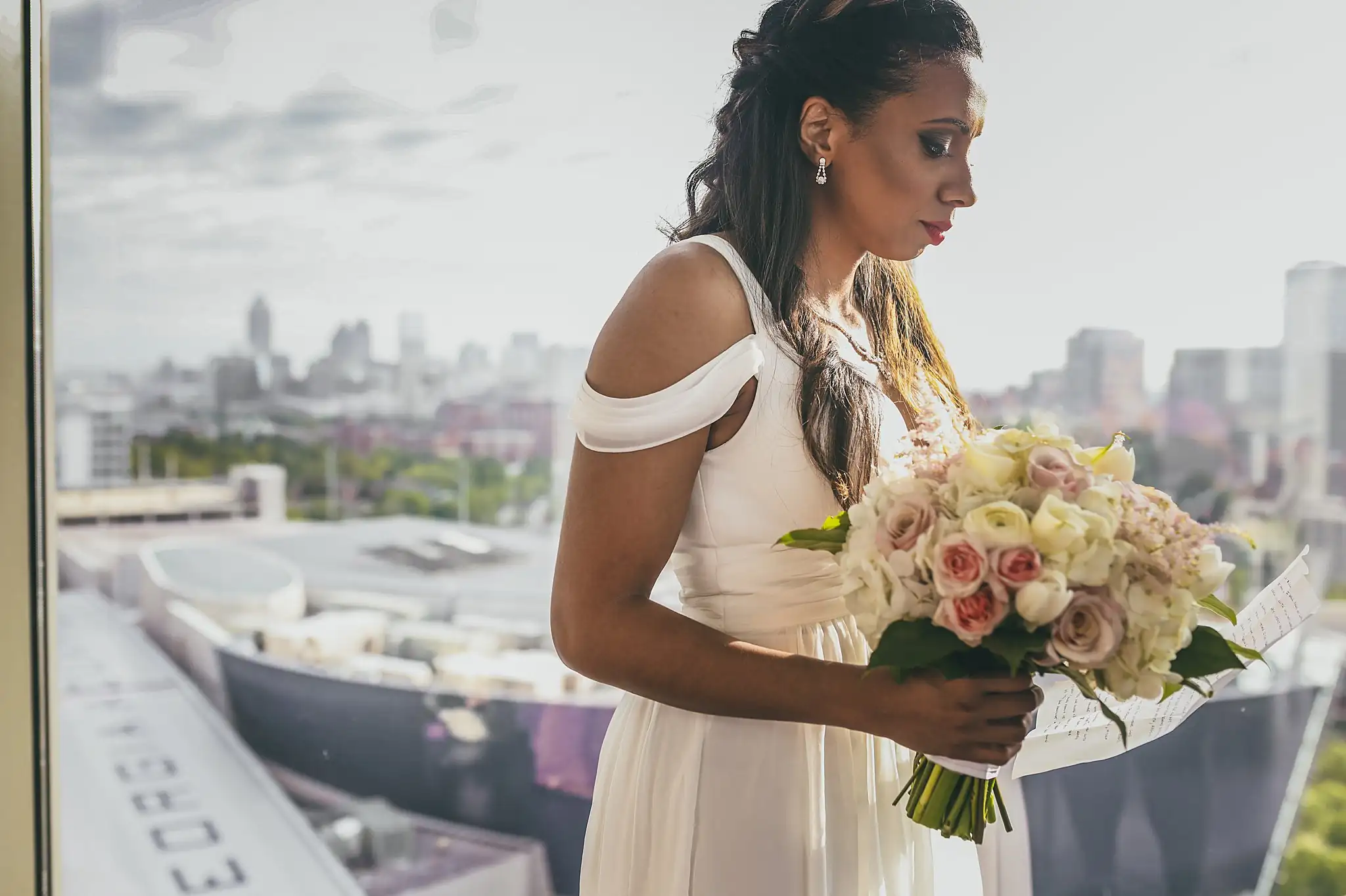 Bridal Portraits: the bride at the window holding her bouquet, at their elopement at Ventanas in Atlanta, GA
