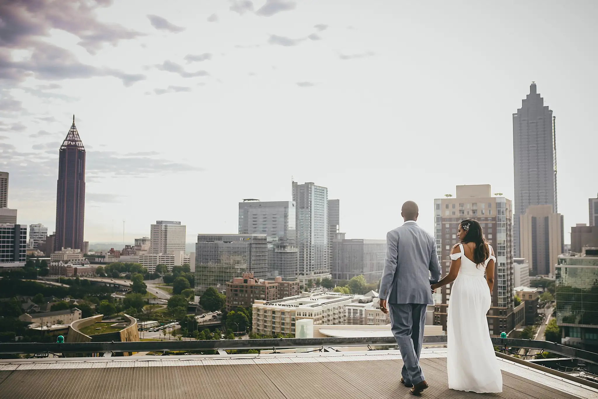 Wedding Formals: the couple walking away across the rooftop toward the city, at their elopement at Ventanas in Atlanta, GA
