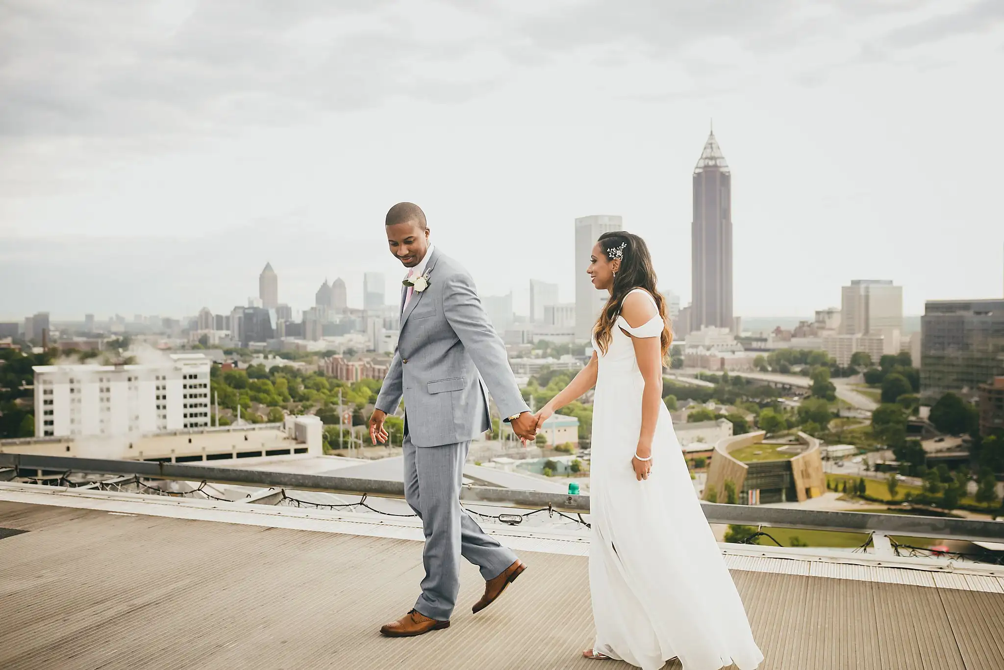 Wedding Formals: the couple walking hand in hand across the rooftop, at their elopement at Ventanas in Atlanta, GA