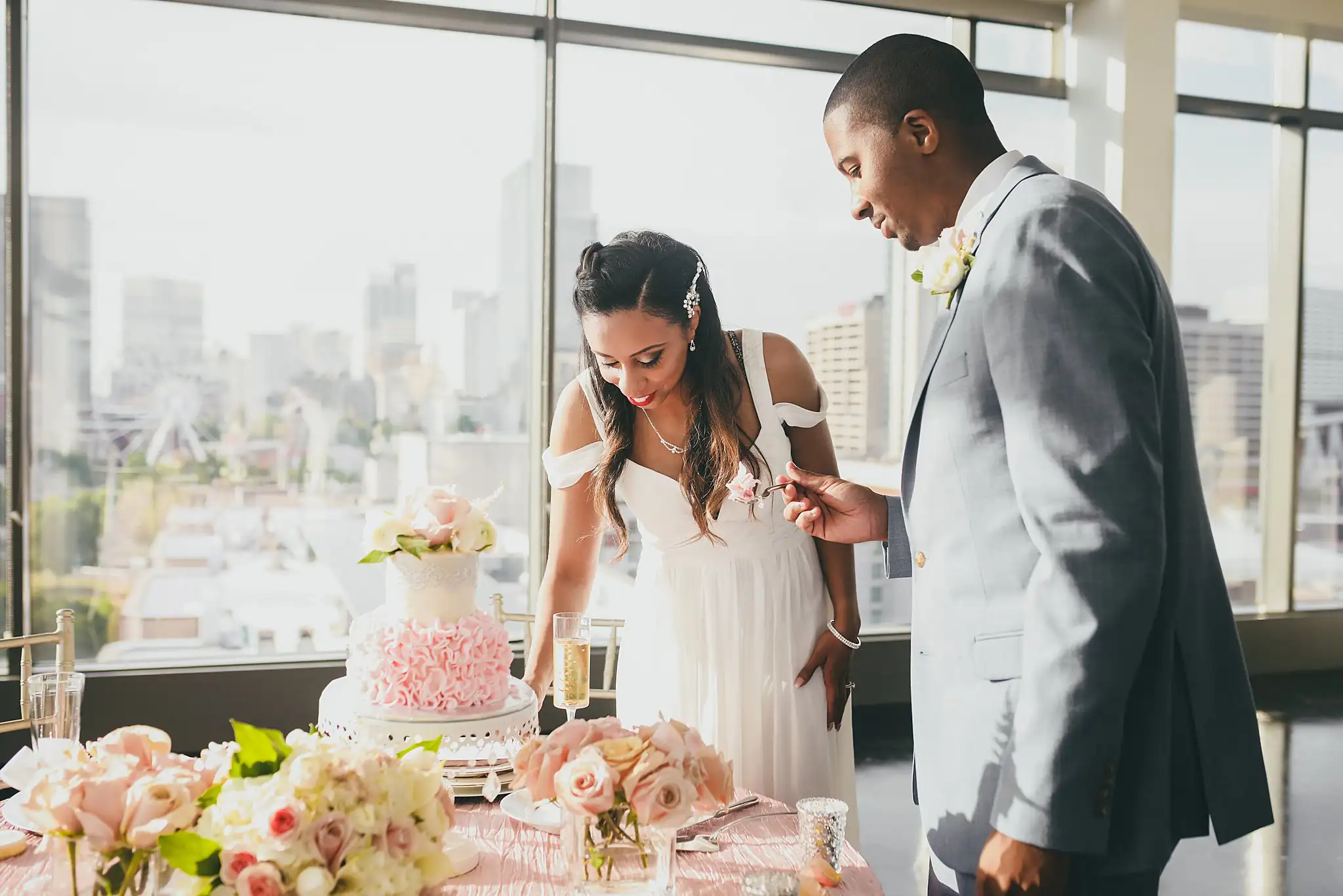 Cake Cutting: the couple making the first cut into the blush ruffled cake, at their elopement at Ventanas in Atlanta, GA