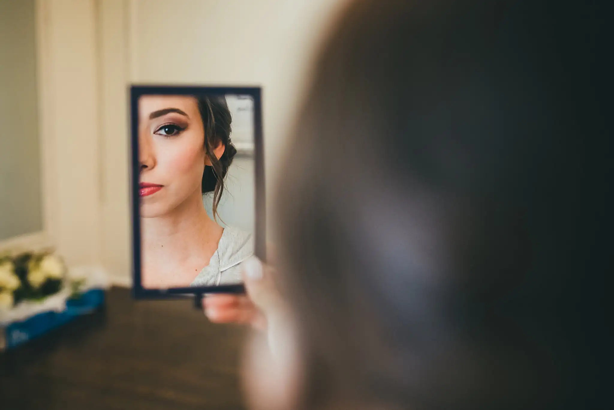 Getting Ready: the bride's face in a hand mirror, before their wedding at Little River Farms in Milton, GA