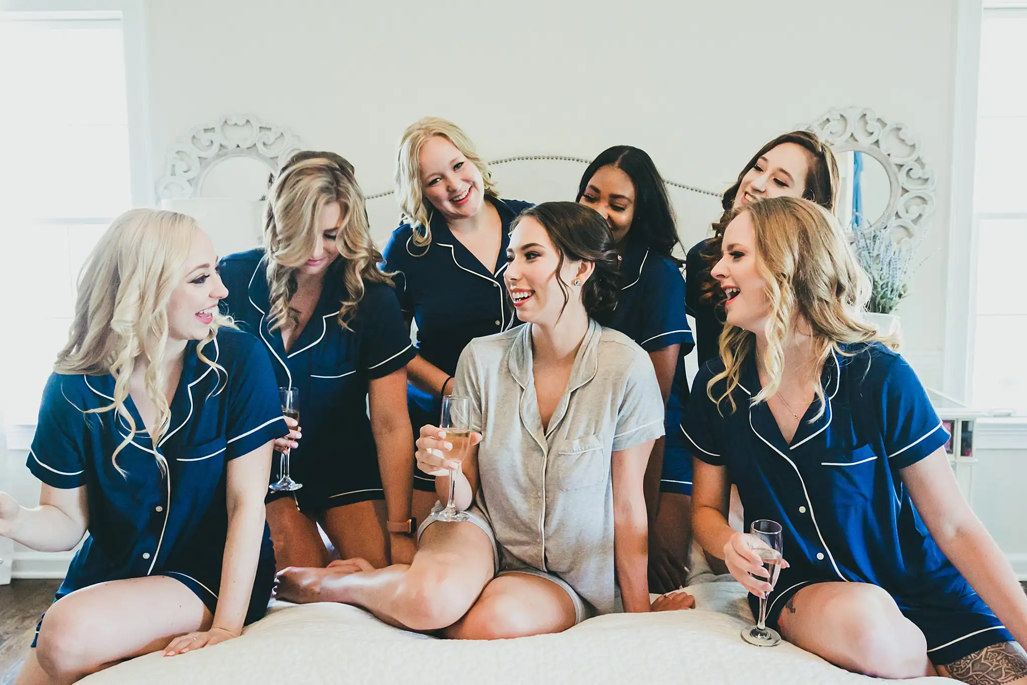 Getting Ready: the bride and bridesmaids with champagne in navy pyjamas, before their wedding at Little River Farms in Milton, GA