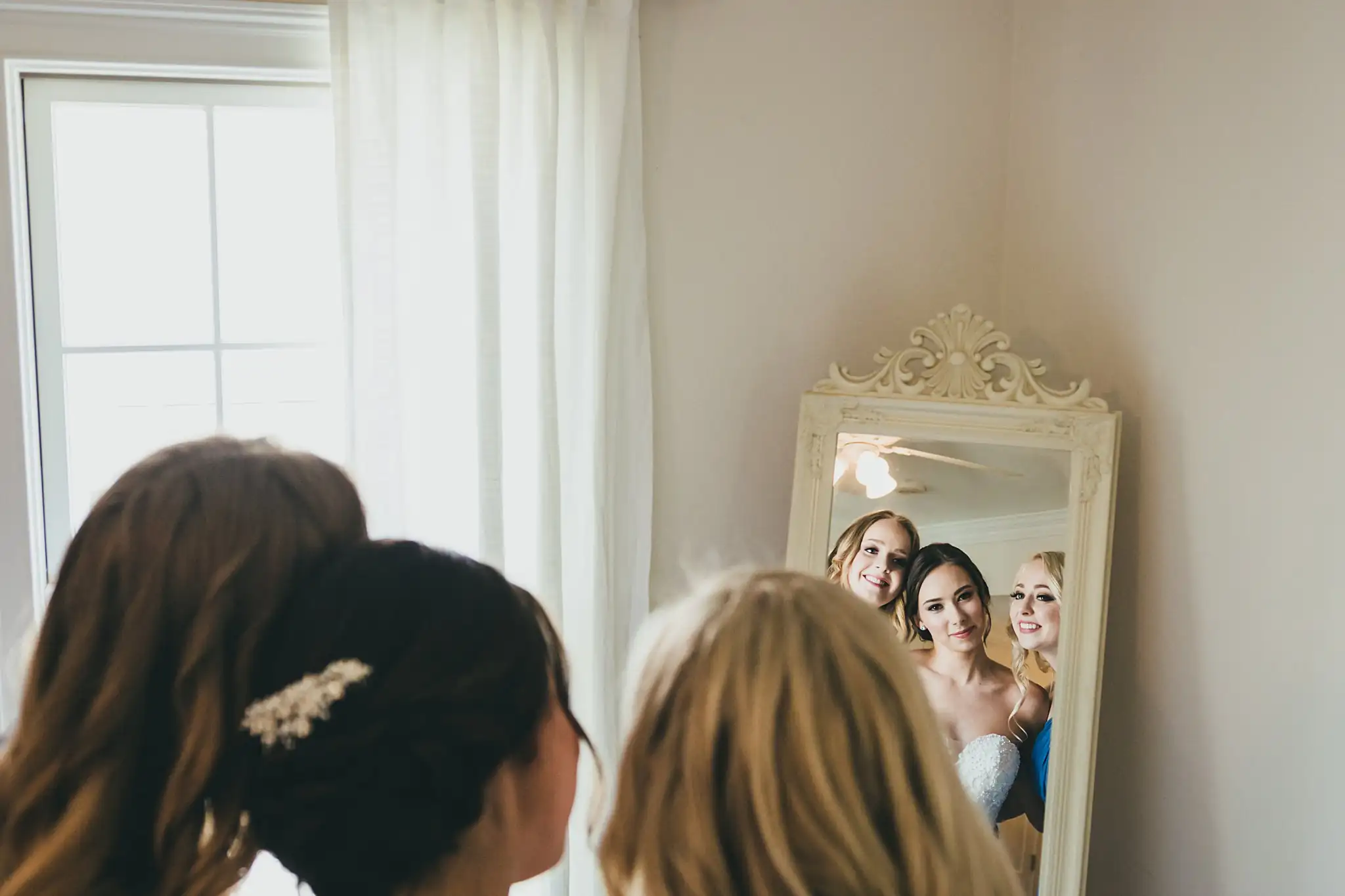 Getting Ready: the bride and bridesmaids in the mirror, before their wedding at Little River Farms in Milton, GA