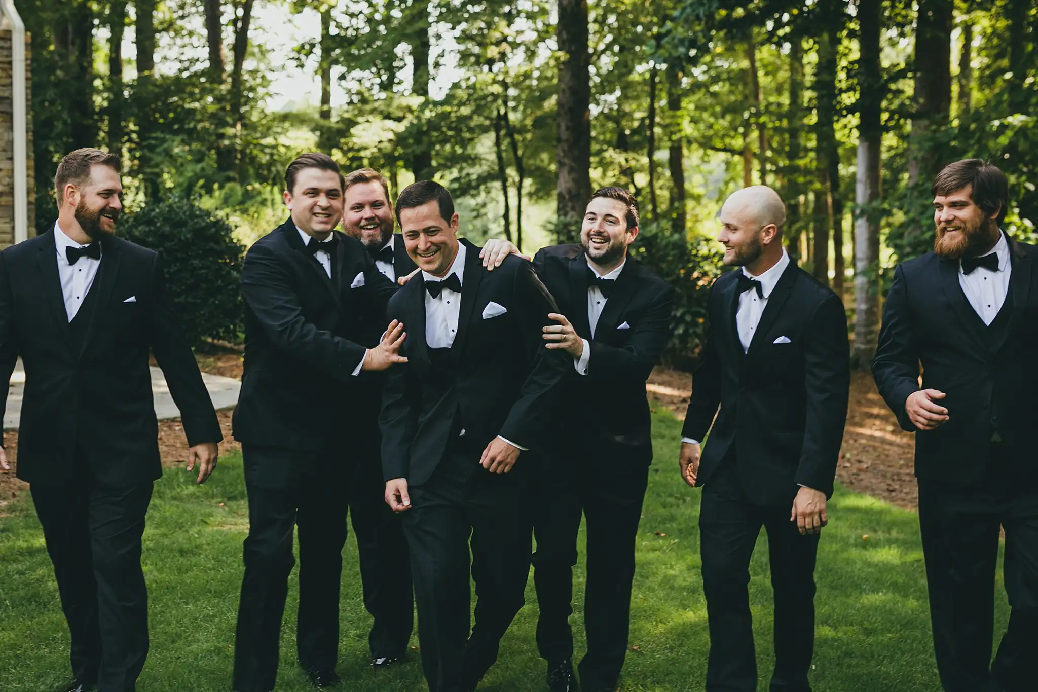 Wedding Party: the groomsmen joking with the groom, at their wedding at Little River Farms in Milton, GA