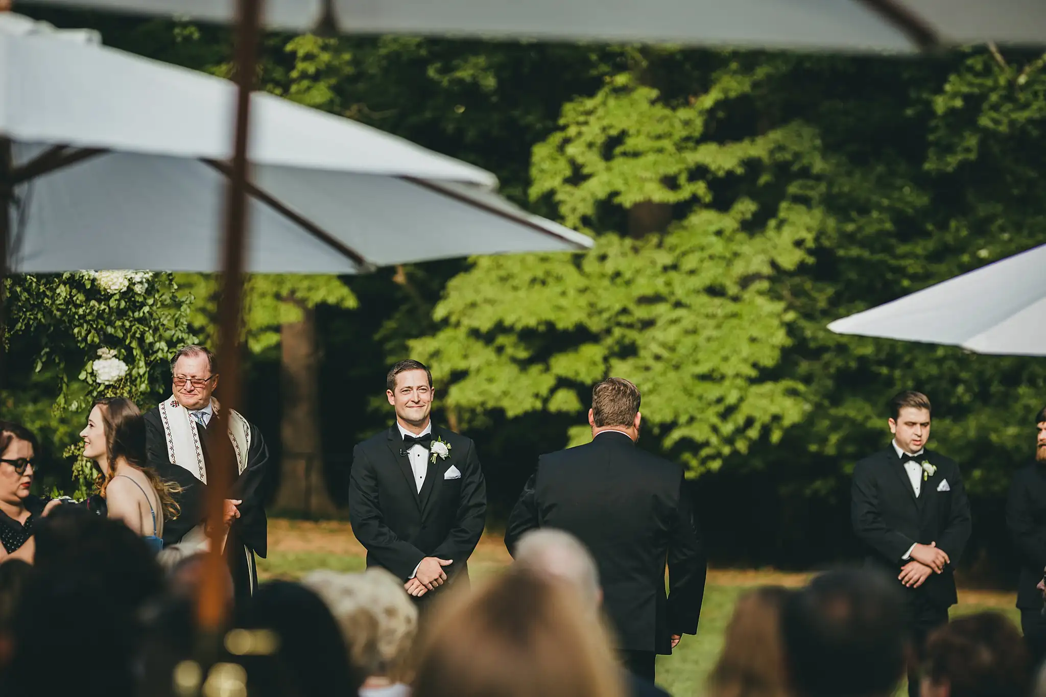 Wedding Ceremony: the groom waiting as the guests settle, at their wedding at Little River Farms in Milton, GA