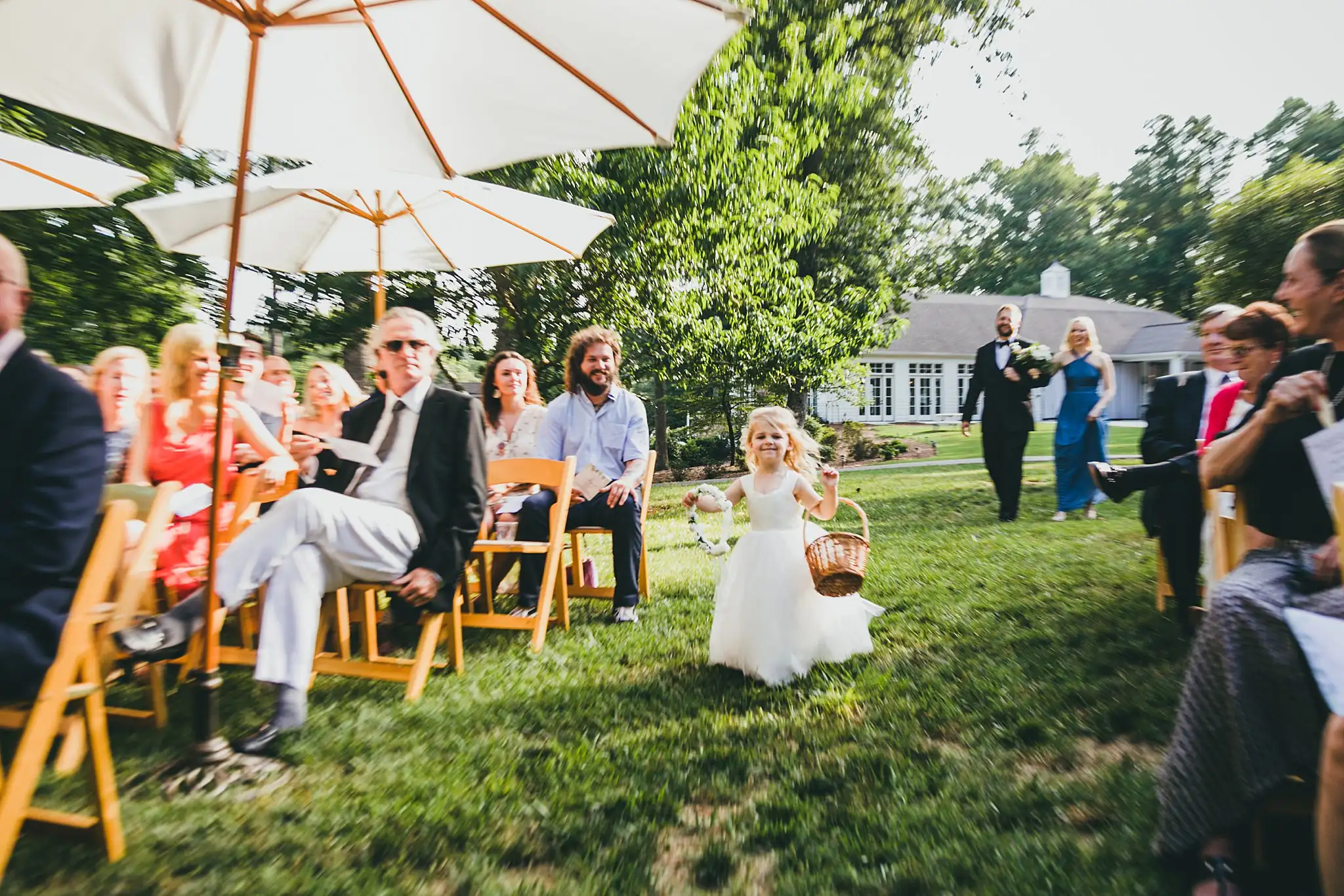 Processional: the flower girl coming down the grass aisle, at their wedding at Little River Farms in Milton, GA