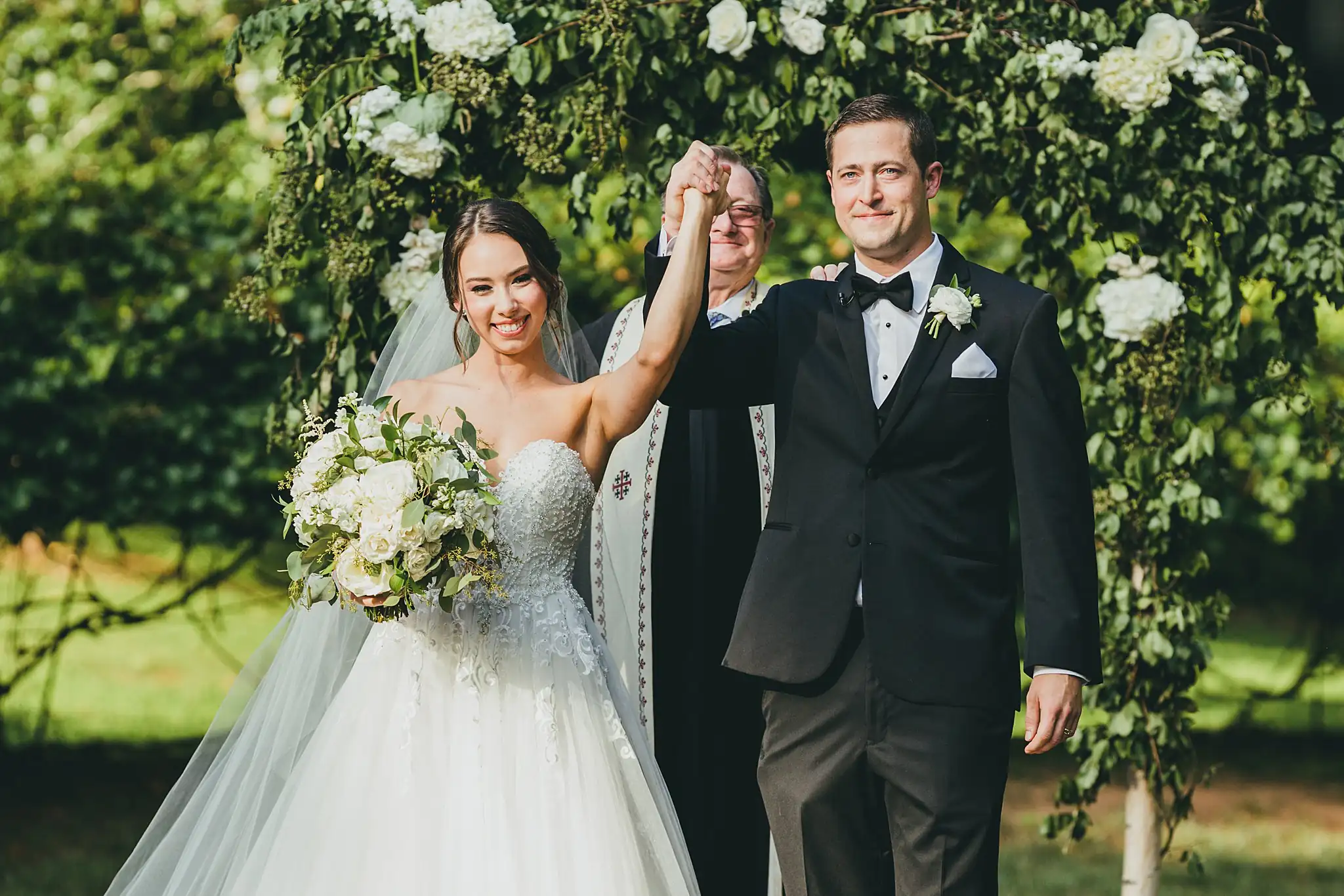 Wedding Ceremony: the couple presented with their hands raised, at their wedding at Little River Farms in Milton, GA