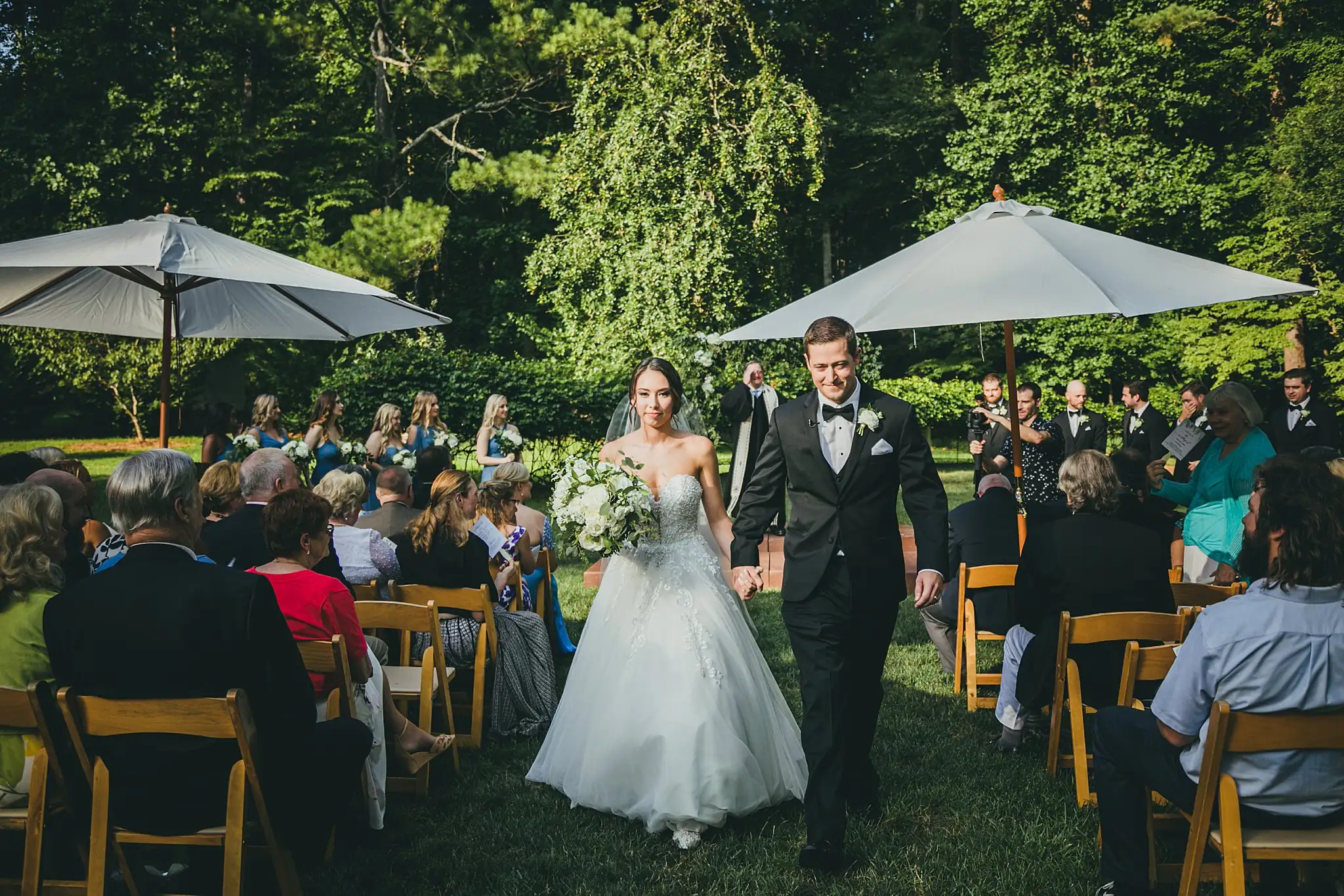 Recessional: the couple walking back down the grass aisle, at their wedding at Little River Farms in Milton, GA
