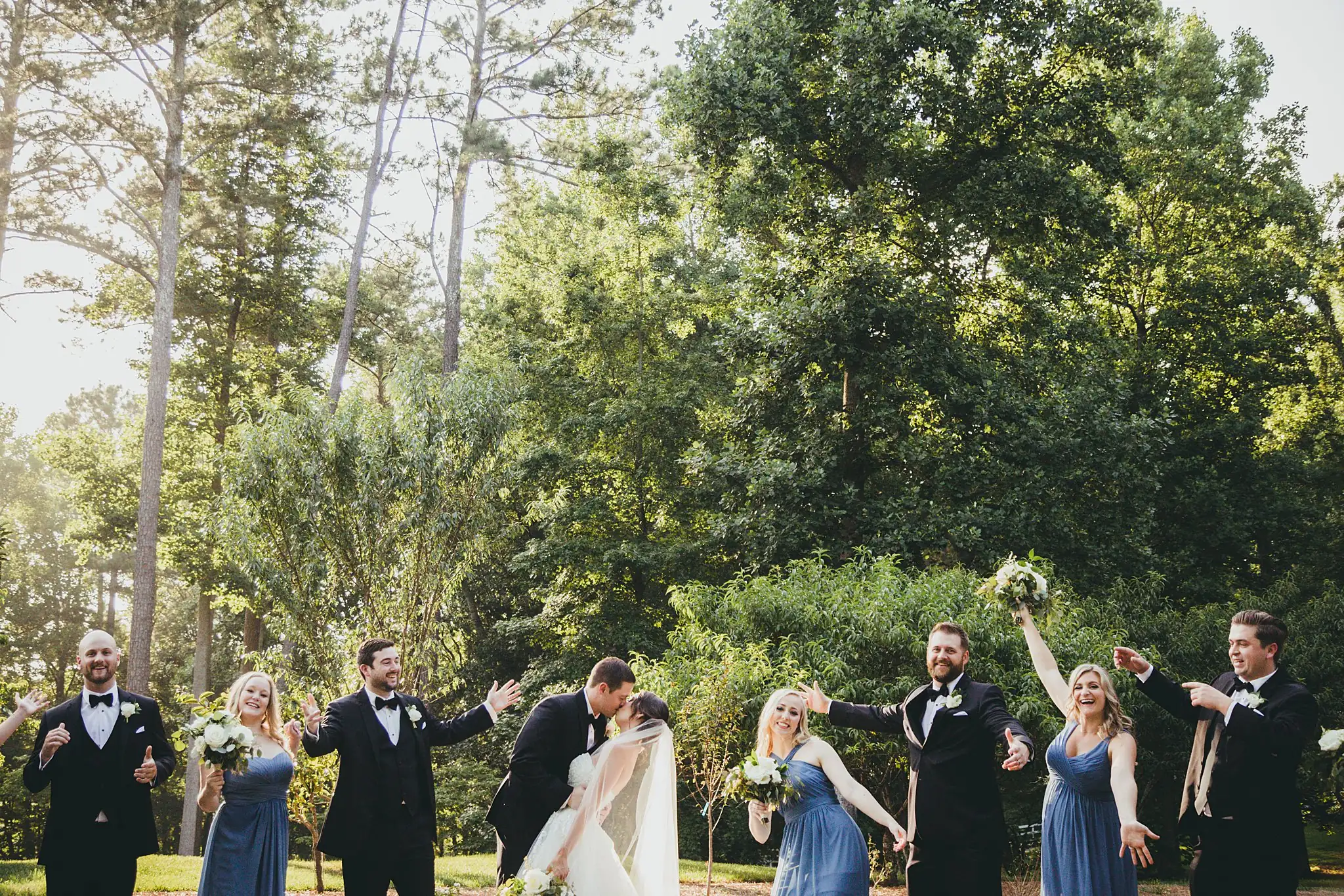 Wedding Party: the bridal party celebrating, arms raised, at their wedding at Little River Farms in Milton, GA