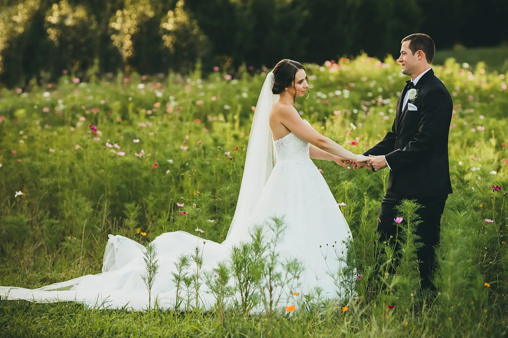 Wedding Formals: the couple holding hands in the wildflowers, at their wedding at Little River Farms in Milton, GA
