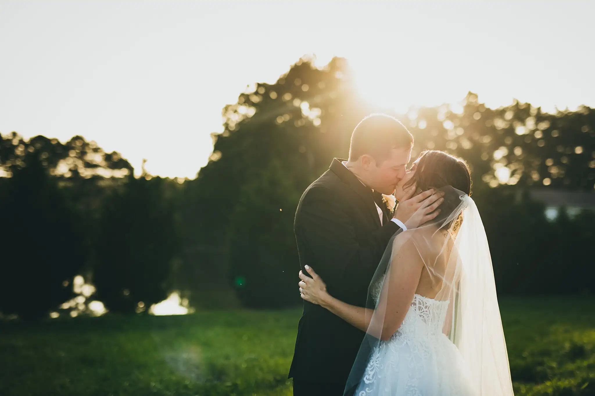 Wedding Formals: the couple kissing as the sun goes down, at their wedding at Little River Farms in Milton, GA