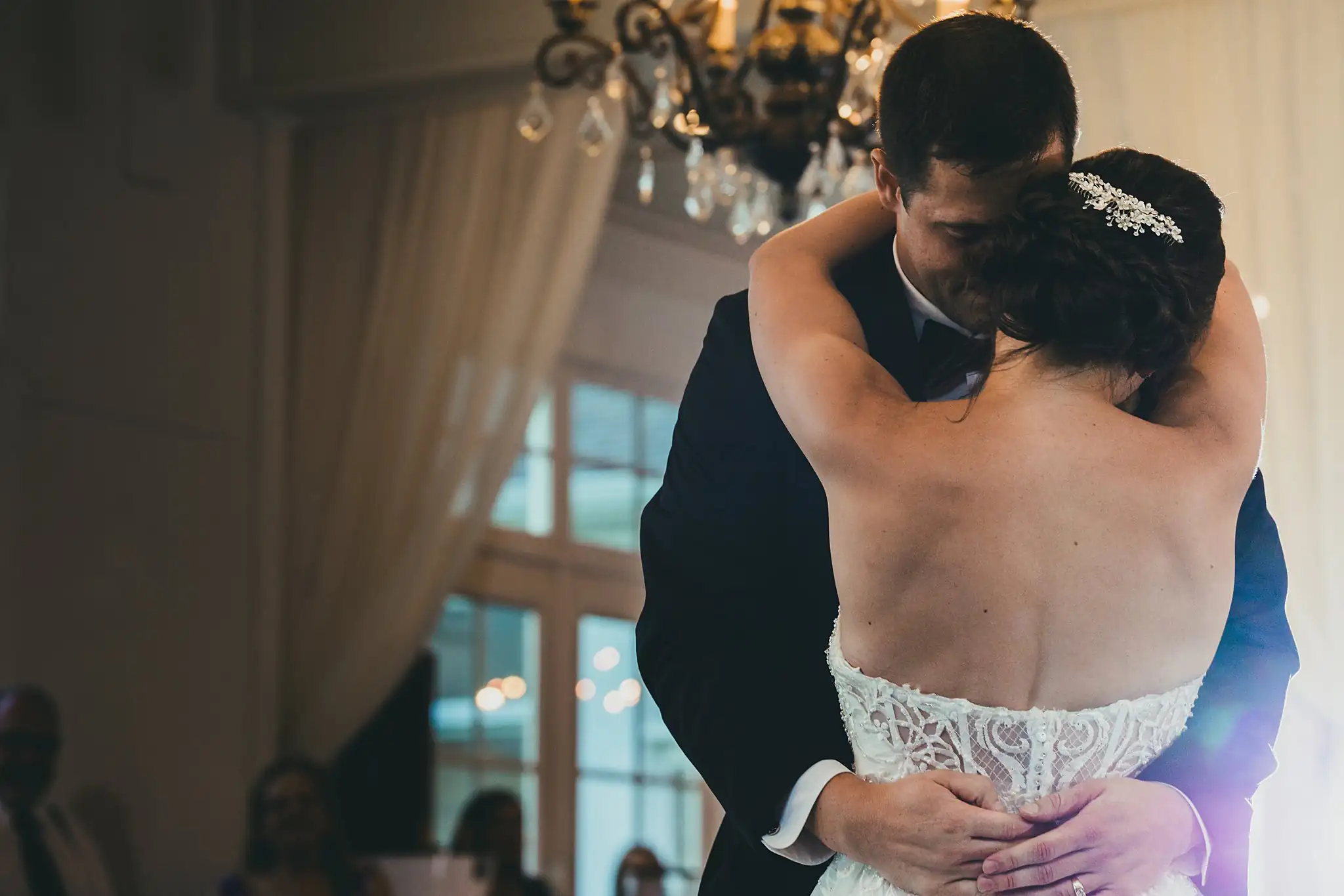 First Dance: the couple dancing beneath a chandelier, at their wedding at Little River Farms in Milton, GA