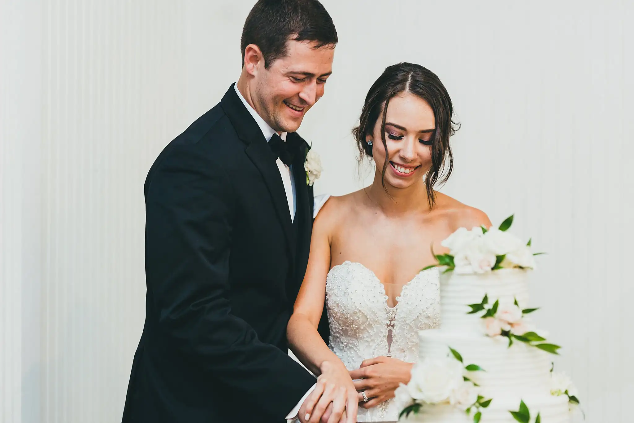 Cake Cutting: the couple smiling after the first cut, at their wedding at Little River Farms in Milton, GA