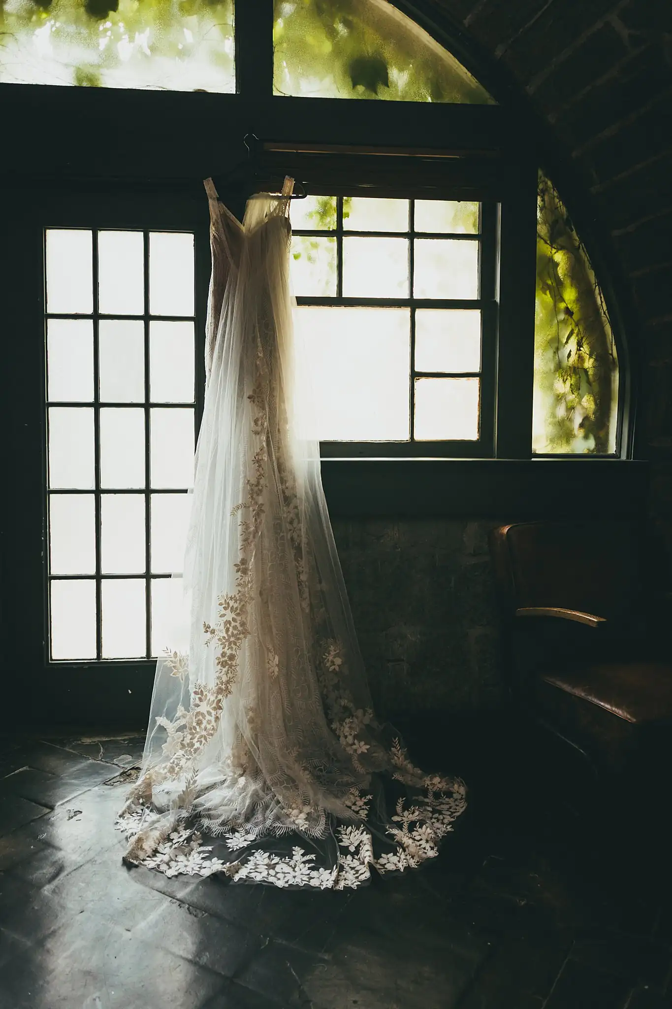 Wedding Details: the lace gown hanging in an arched window, at a wedding at the Piedmont Garden Tent in Atlanta, GA