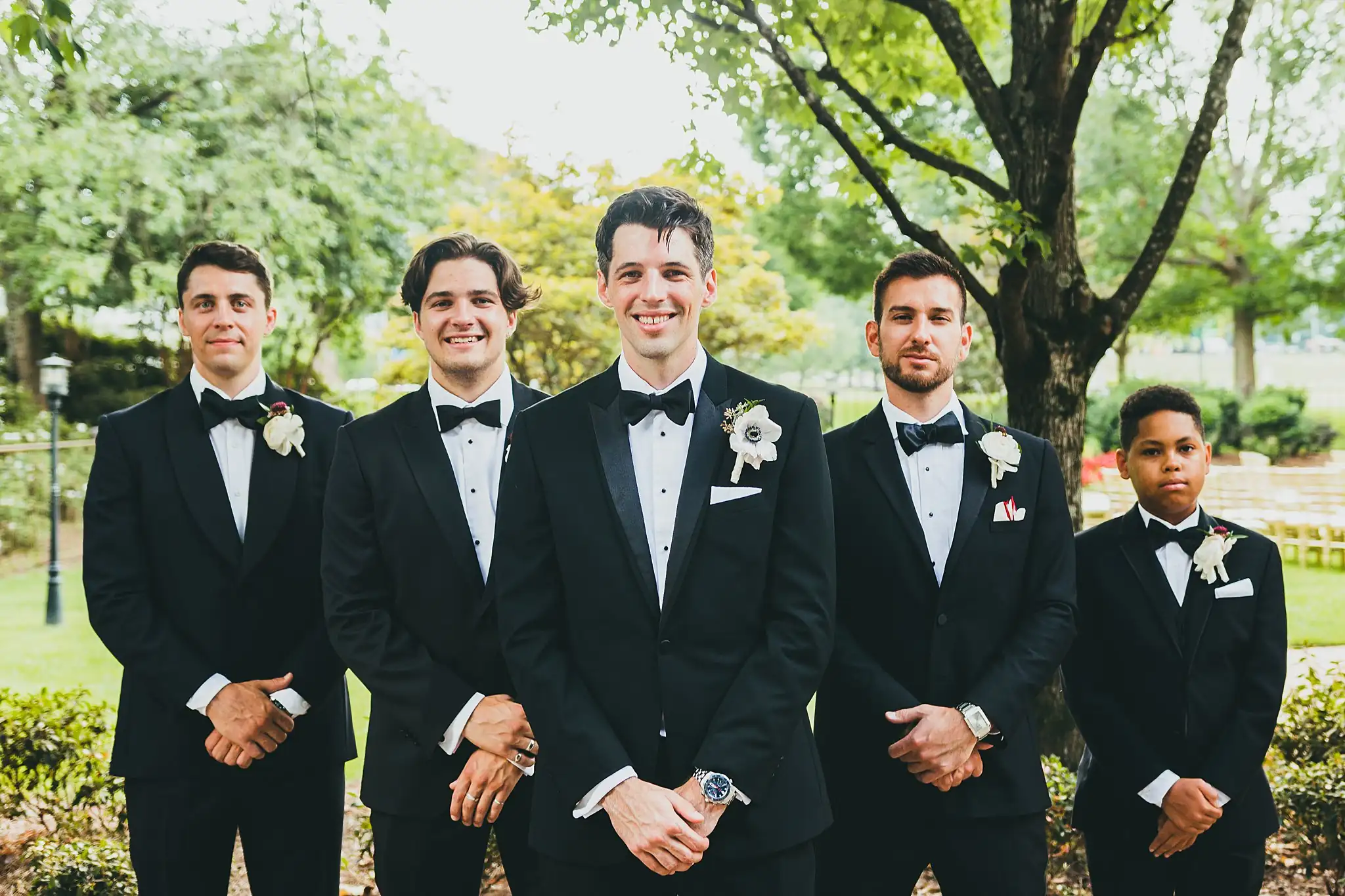Wedding Party: the groomsmen lined up beneath the trees, at their wedding at the Piedmont Garden Tent in Atlanta, GA