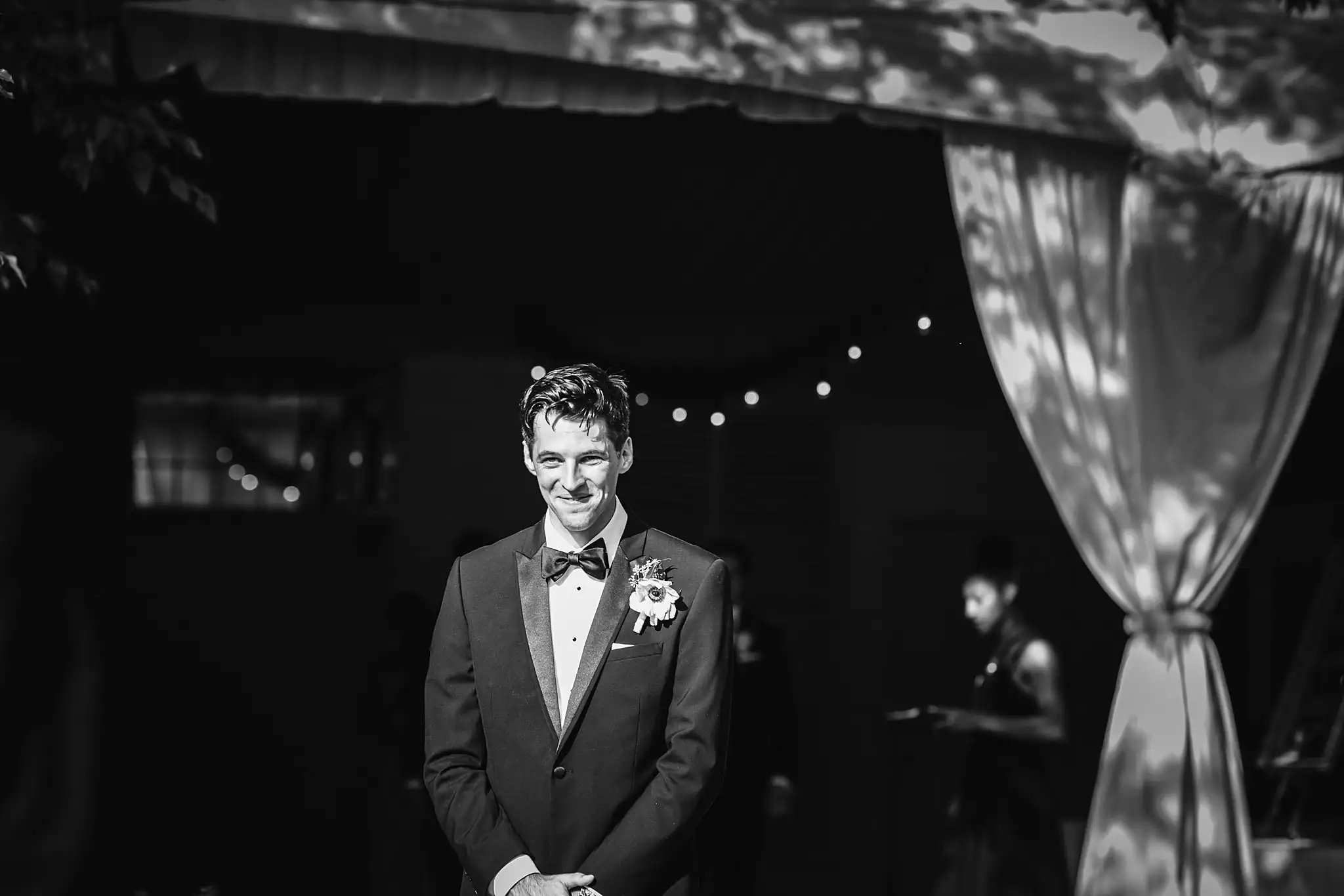Wedding Ceremony: the groom waiting under the tent drapes, at their wedding at the Piedmont Garden Tent in Atlanta, GA