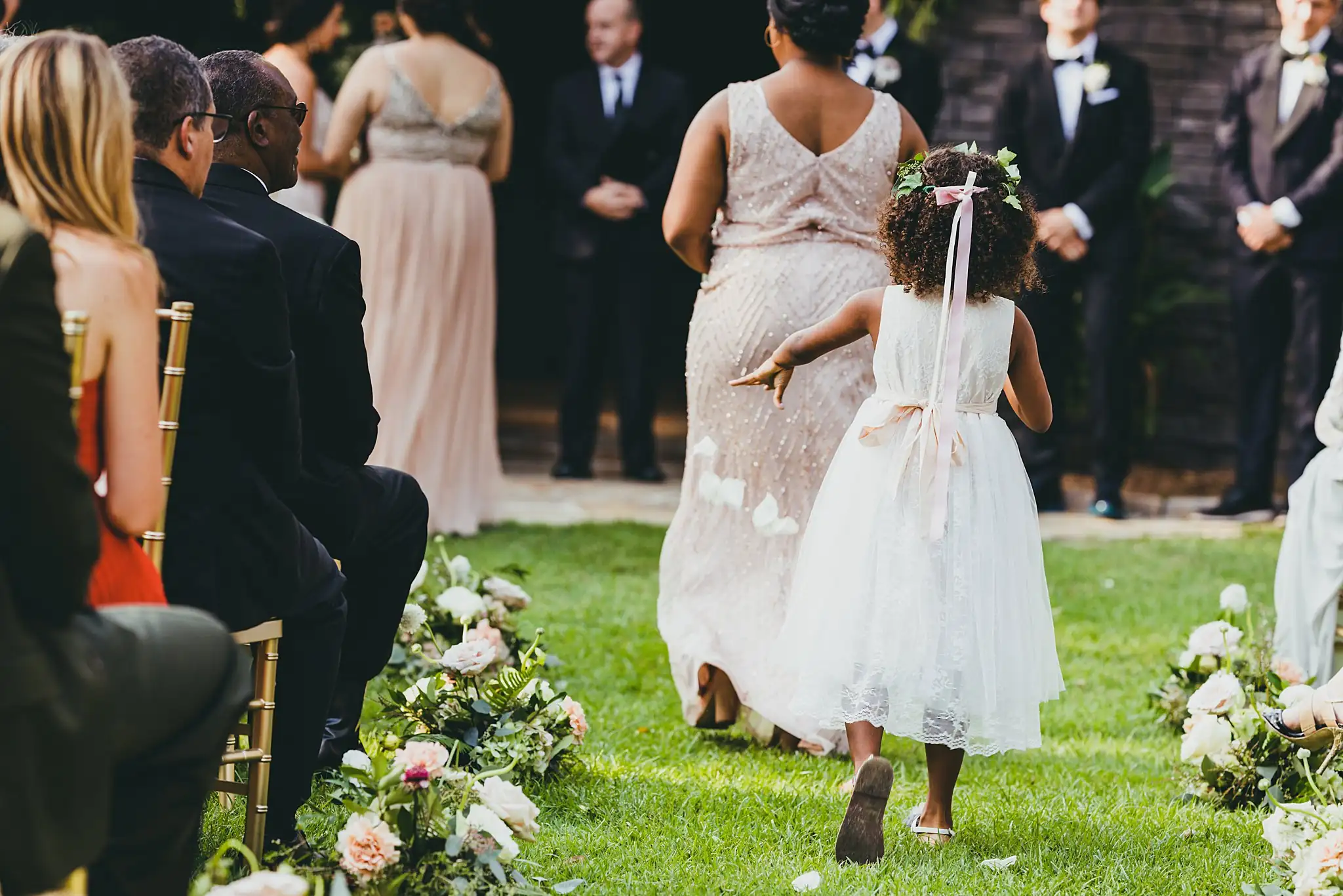 Processional: the flower girl walking the grass aisle, at their wedding at the Piedmont Garden Tent in Atlanta, GA