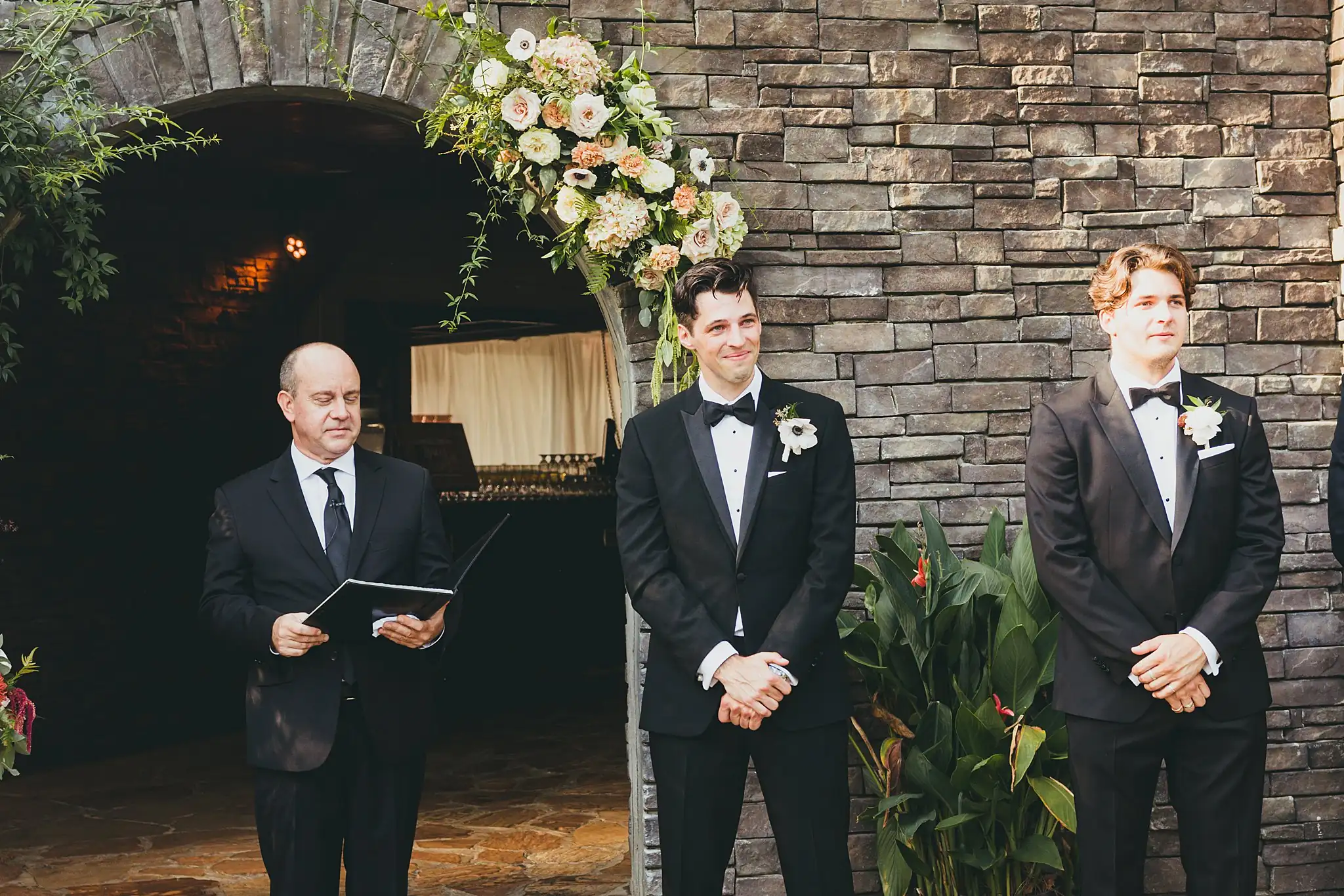 Wedding Ceremony: the officiant and groom at the arched wall, at their wedding at the Piedmont Garden Tent in Atlanta, GA