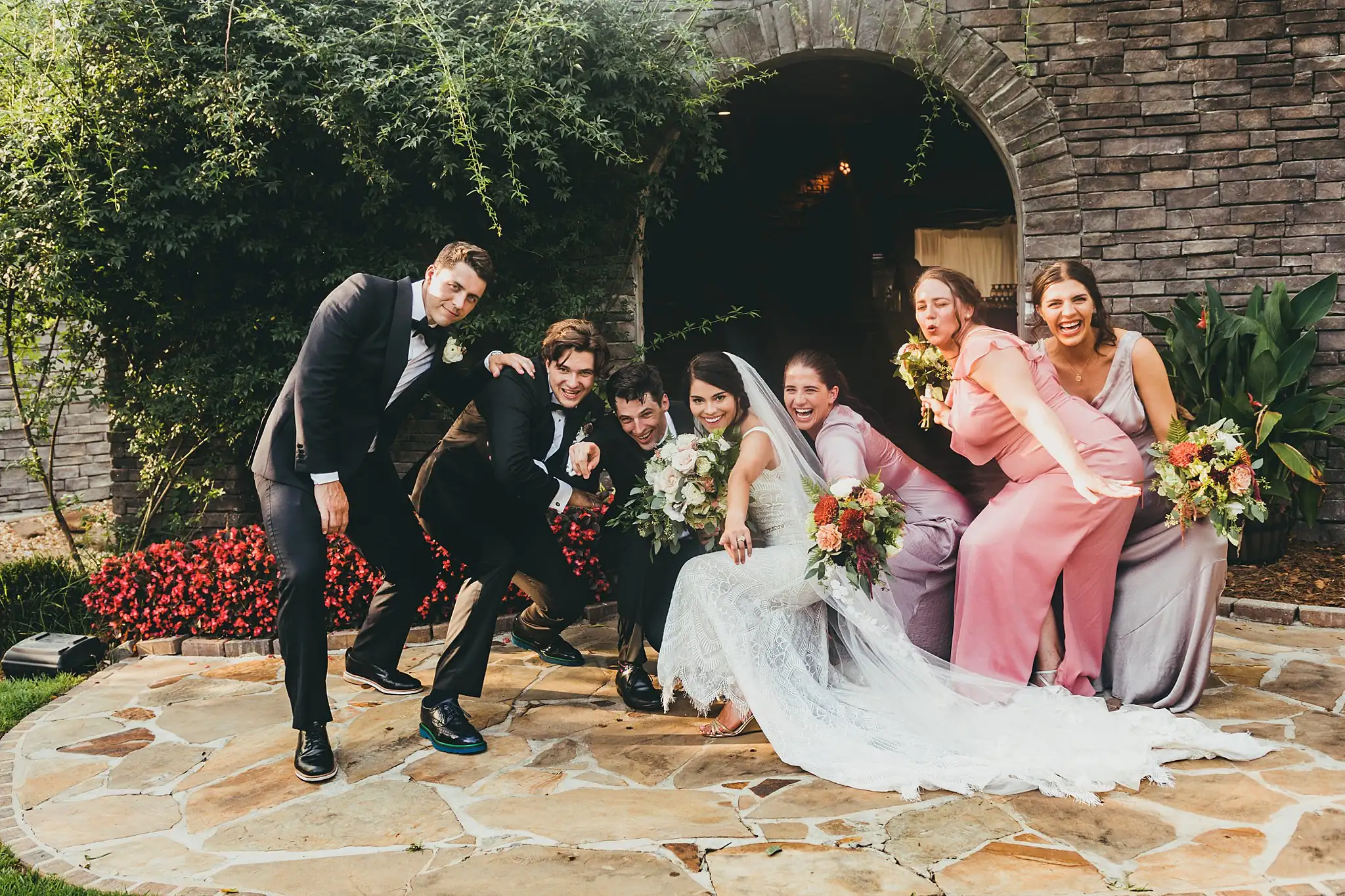 Wedding Party: the bridal party clowning, the groom crouched, at their wedding at the Piedmont Garden Tent in Atlanta, GA
