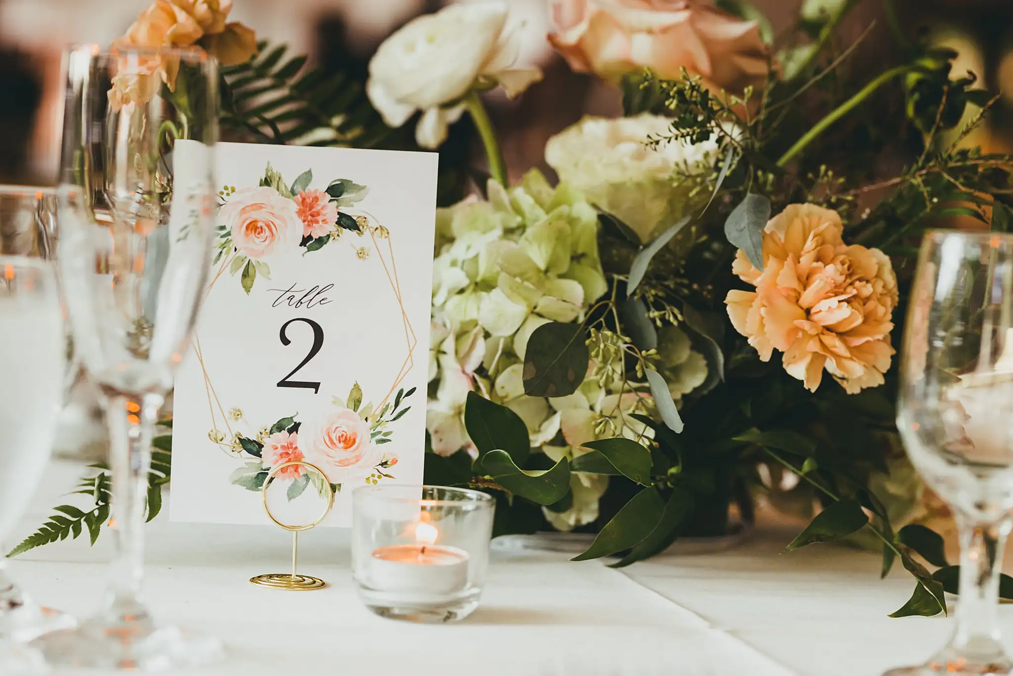 Reception Details: a table number card among peach flowers, at their wedding at the Piedmont Garden Tent in Atlanta, GA
