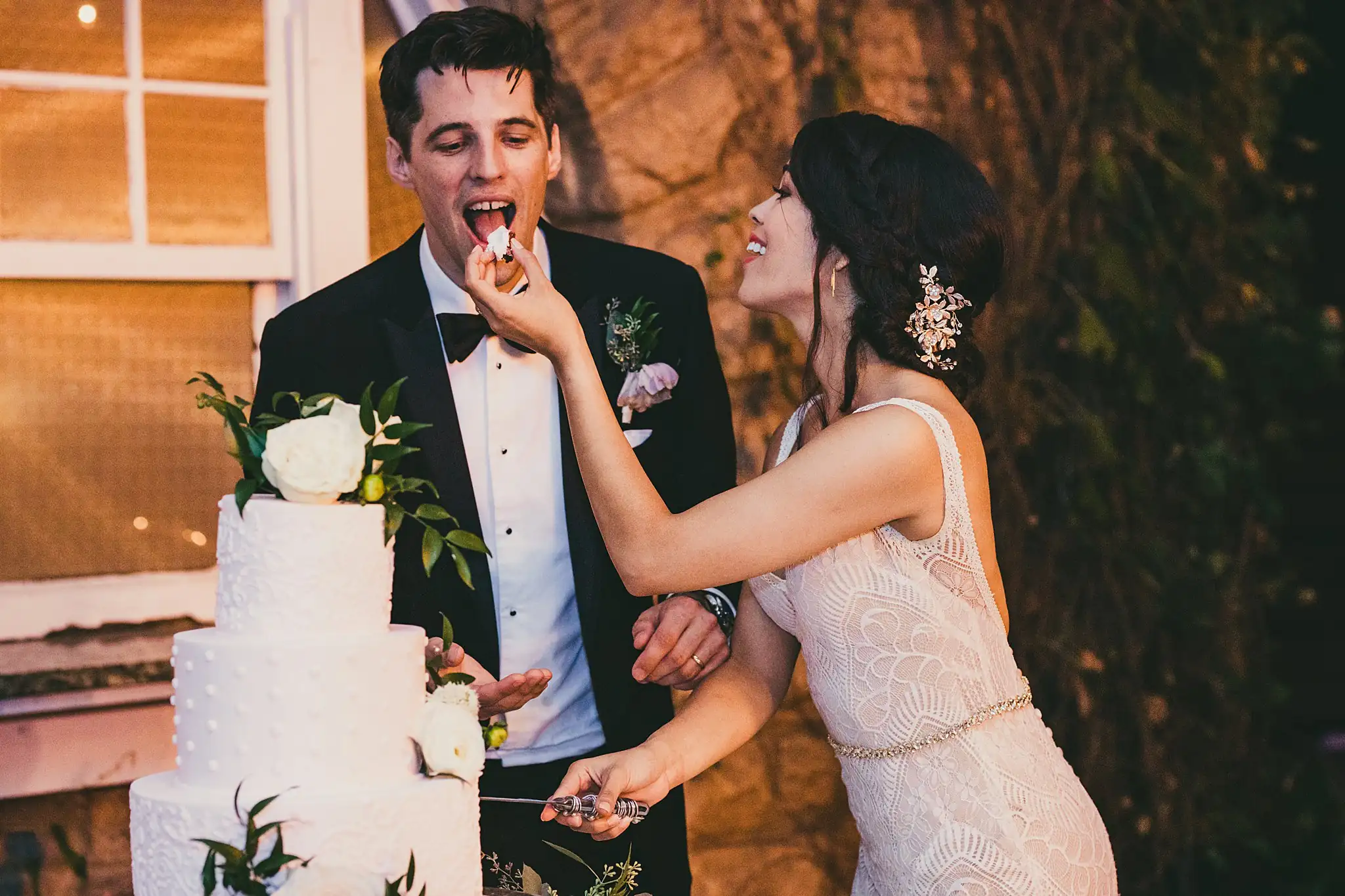 Cake Cutting: the bride feeding the groom a bite of cake, at their wedding at the Piedmont Garden Tent in Atlanta, GA