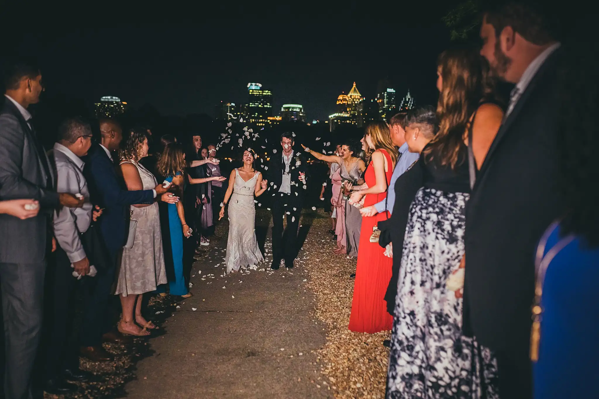 Send-Off: the confetti send-off with the city skyline behind, at their wedding at the Piedmont Garden Tent in Atlanta, GA