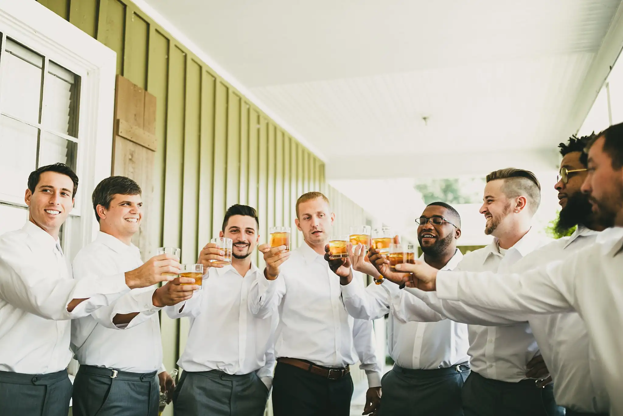 Getting Ready: the groomsmen toasting on the porch, before their wedding at Houston Lake Country Club in Perry, GA