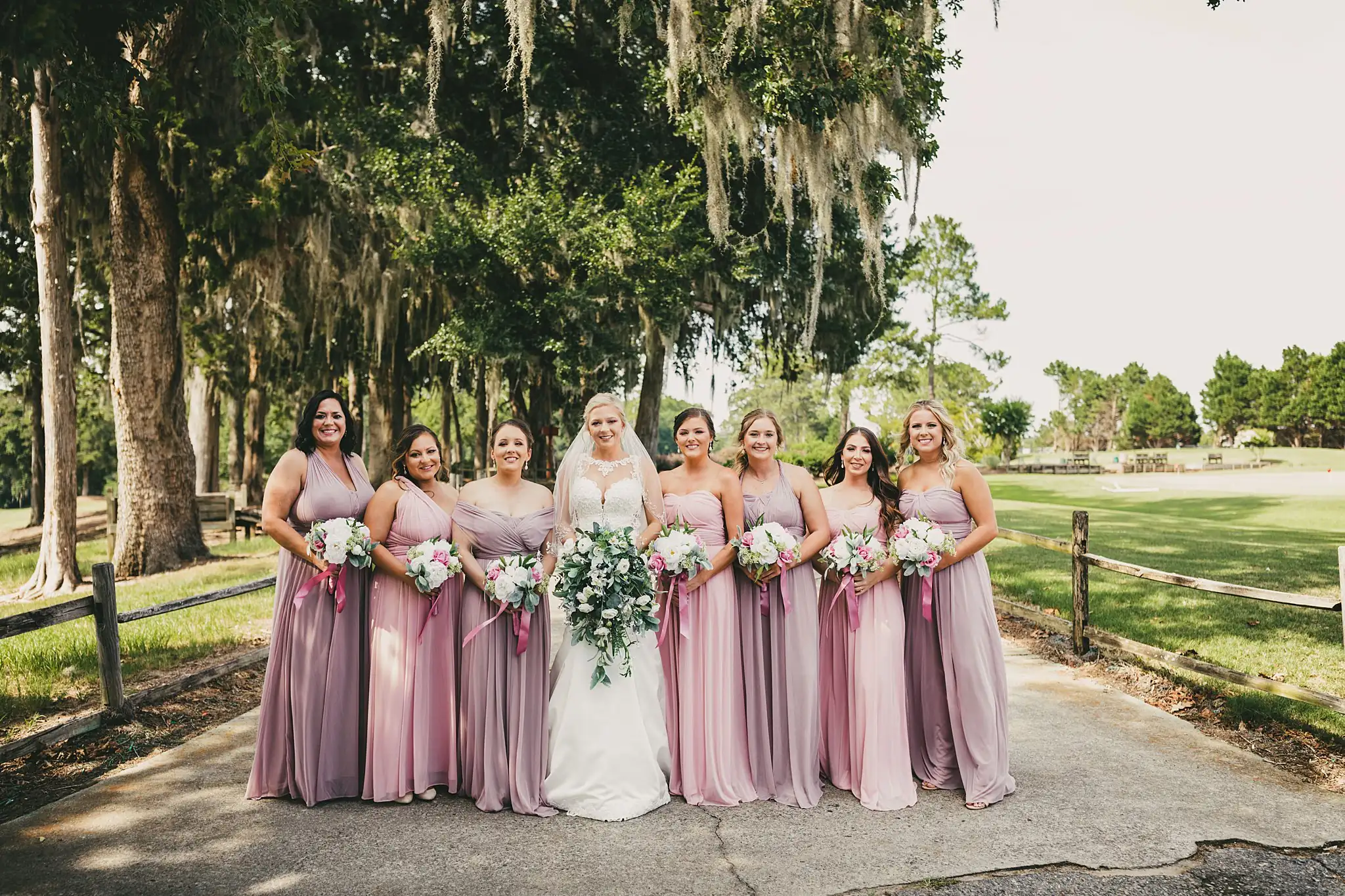 Wedding Party: the bride and bridesmaids beneath the mossy oaks, at their wedding at Houston Lake Country Club in Perry, GA