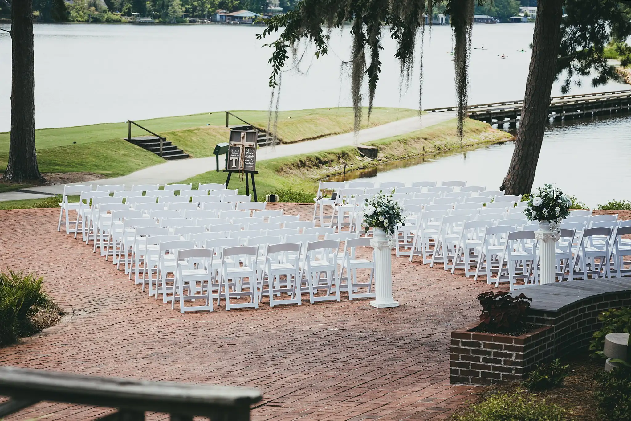 Wedding Ceremony: white chairs set out with the lake behind, at a wedding at Houston Lake Country Club in Perry, GA