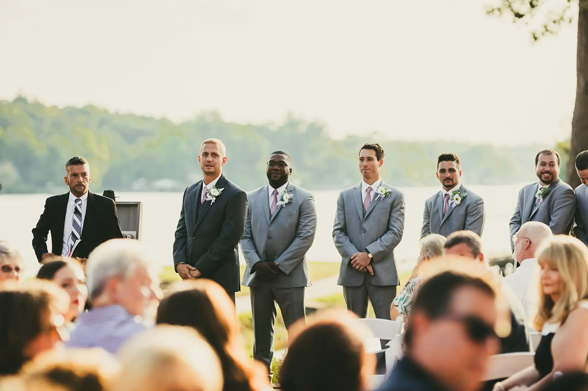 Wedding Ceremony: the groomsmen standing at the water's edge, at their wedding at Houston Lake Country Club in Perry, GA
