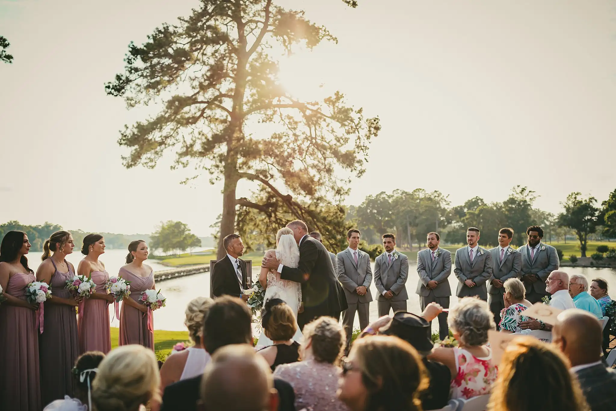Wedding Ceremony: the ceremony under the mossy oaks by the lake, at their wedding at Houston Lake Country Club in Perry, GA