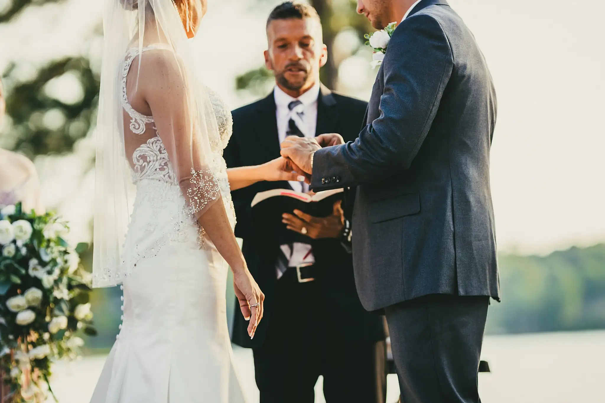 Wedding Ceremony: the ring exchange before the officiant, at their wedding at Houston Lake Country Club in Perry, GA